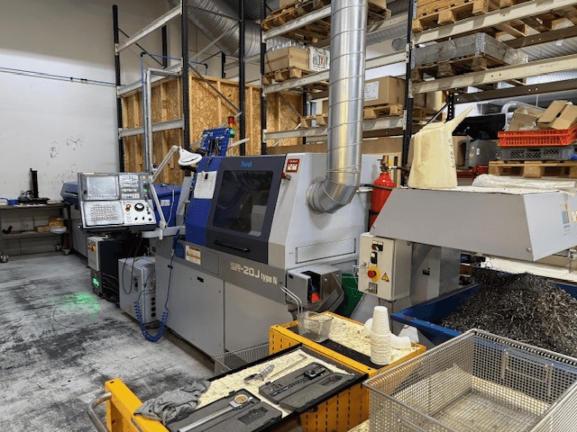 Pohled zepředu na obráběcí centrum Faroh SPR-20J typu N s ovládacím panelem, kovovými hoblinami a bezpečnostním vybavením v dílně.