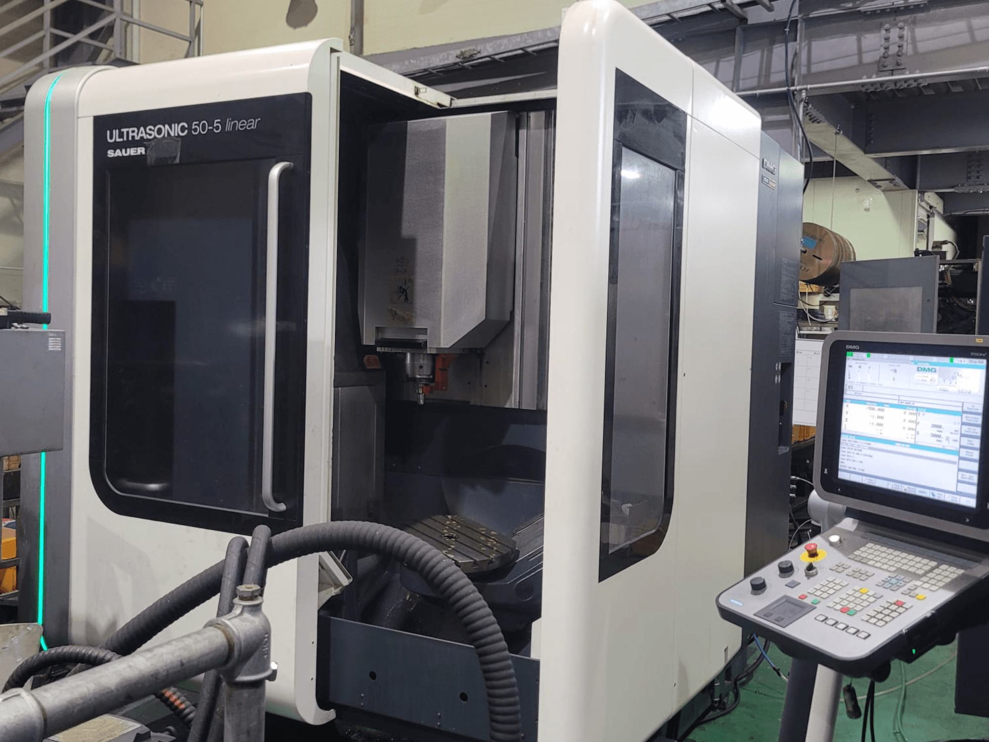 Lineární univerzální obráběcí centrum DMG ULTRASONIC 50-5, pohled zepředu s ovládacím panelem a viditelným pracovním prostorem.