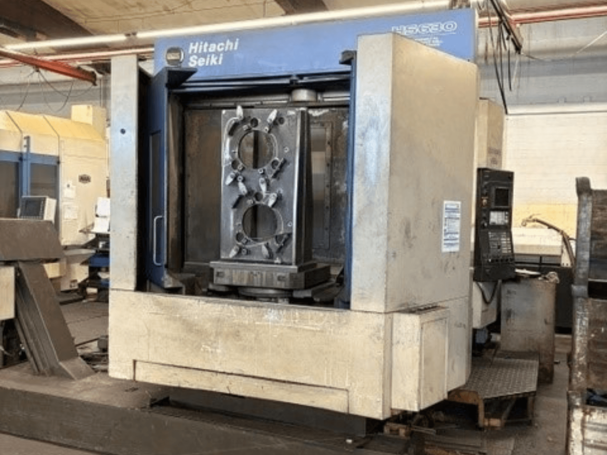 Horizontální obráběcí centrum Hitachi Seiki HS630, pohled zepředu s obrobkem a ovládacím panelem.