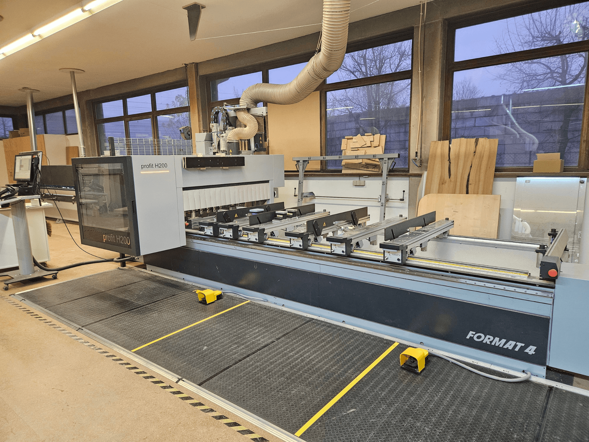 Formát 4 Profit H200 CNC stroj, pohled zepředu, s viditelným řezacím ložem, ovládacím panelem a systémem odsávání prachu.