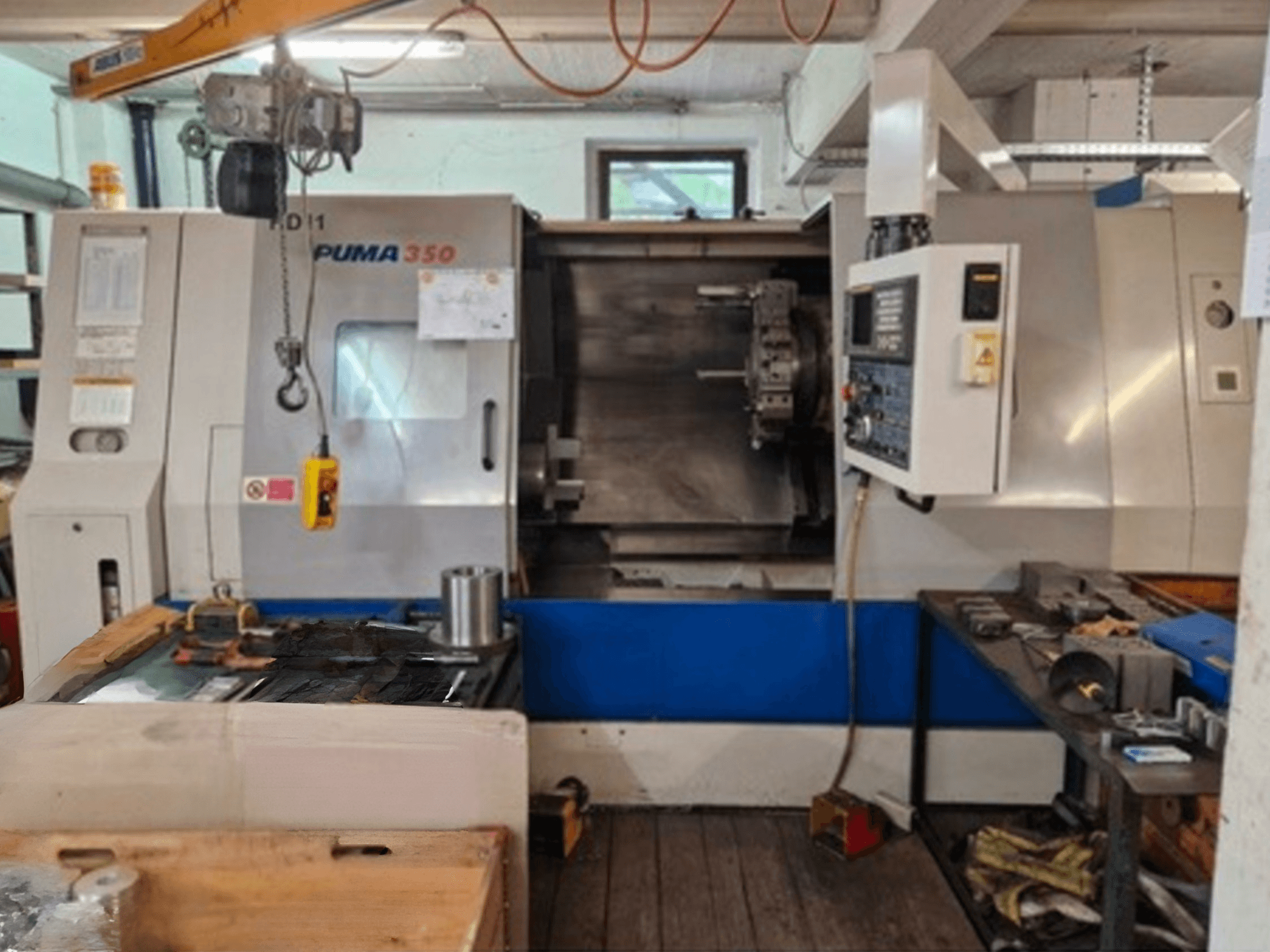 Horizontální soustruh DAEWOO Puma 350, boční pohled, ovládací panel a pracovní plocha s nástroji a materiály v blízkosti.