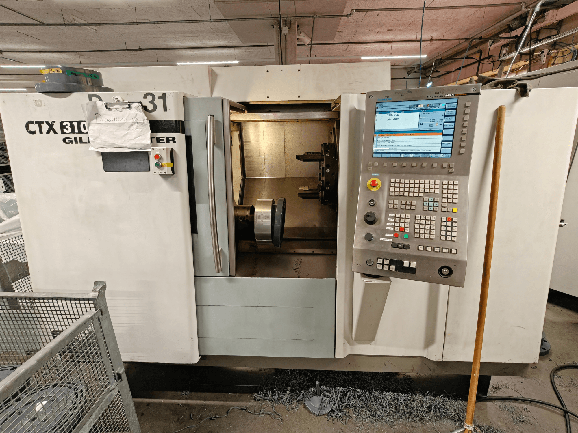 Horizontální soustruh Gildemeister CTX 310, pohled zepředu s ovládacím panelem, znázornění nástrojů a pracovního prostoru uvnitř.