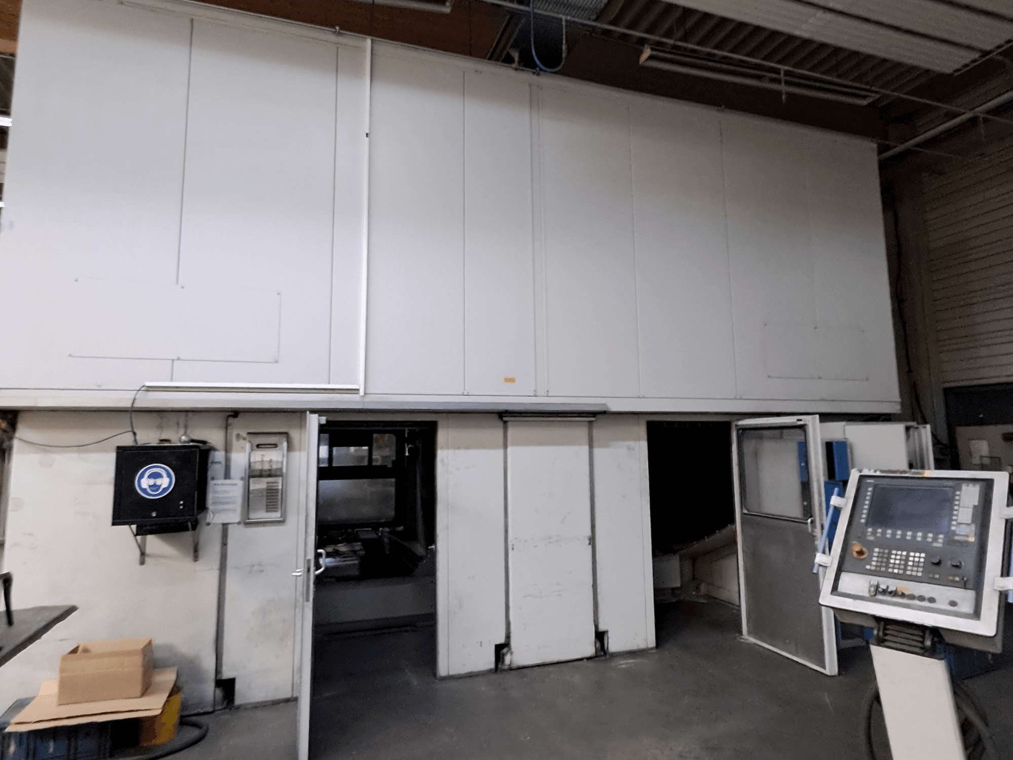 Portálová frézka MAKA Moving Beam 840D, pohled zepředu s otevřenými dvířky, které odhalují vnitřní prostor a viditelný ovládací panel.