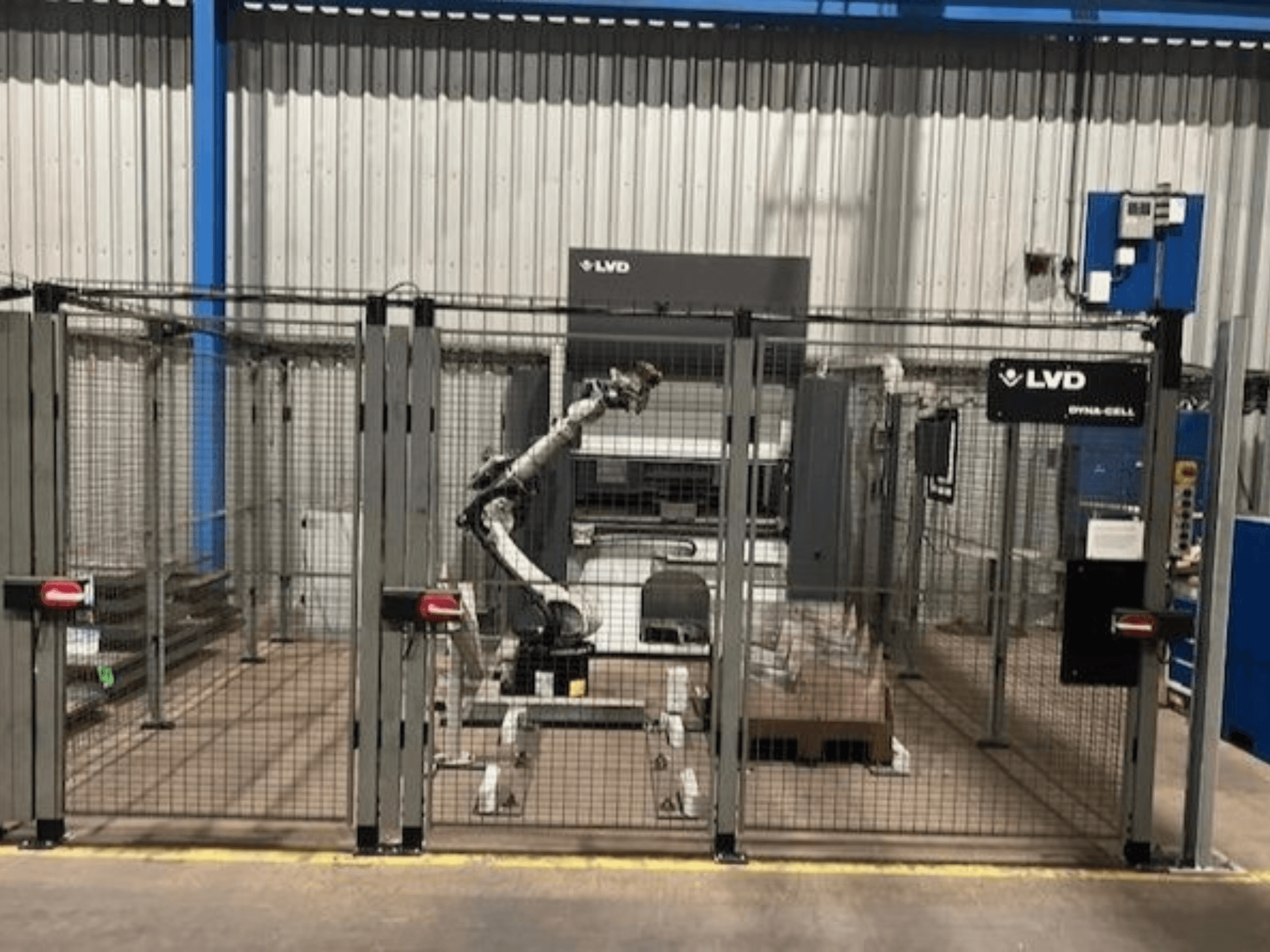 Robotické pracoviště LVD Dyna-Cell v oploceném krytu, pohled zepředu, s robotickým ramenem a ovládacím panelem.
