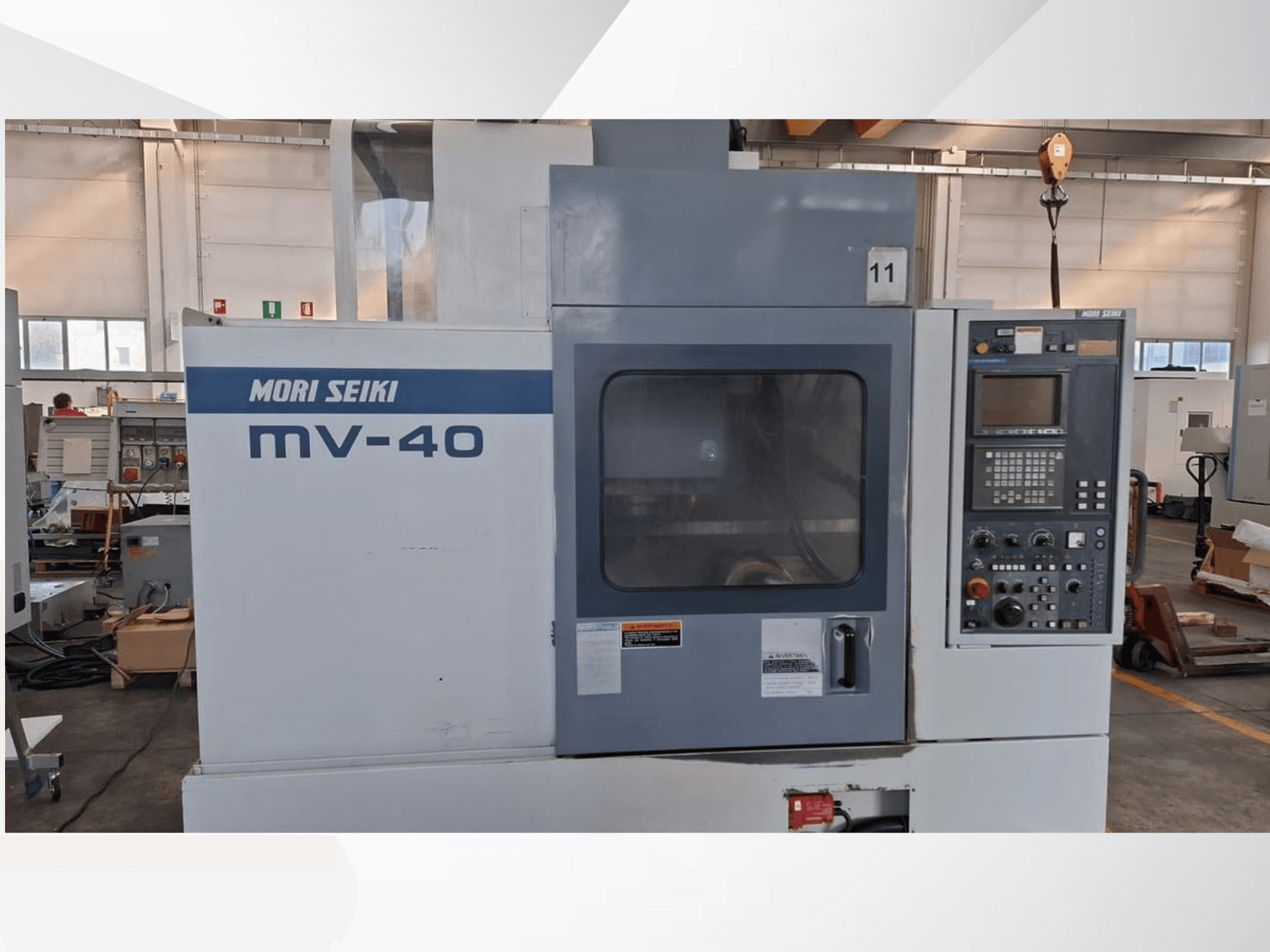 Vertikální obráběcí centrum MORI SEIKI MV-40, pohled zepředu, ovládací panel a okno, v dílenském prostředí.