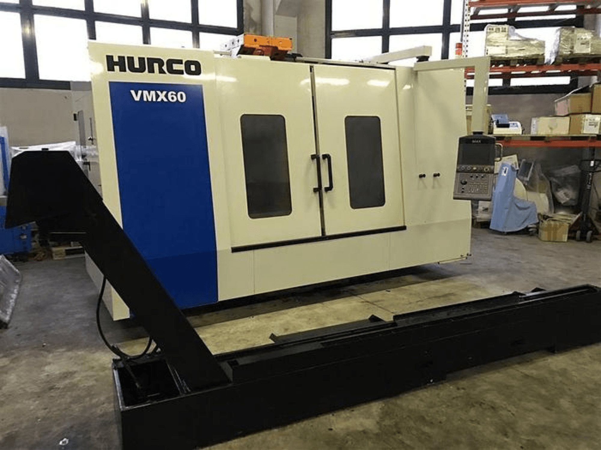 CNC stroj HURCO VMX60 v dílně, pohled zepředu, s ovládacím panelem a připojenou černou nosnou lištou.