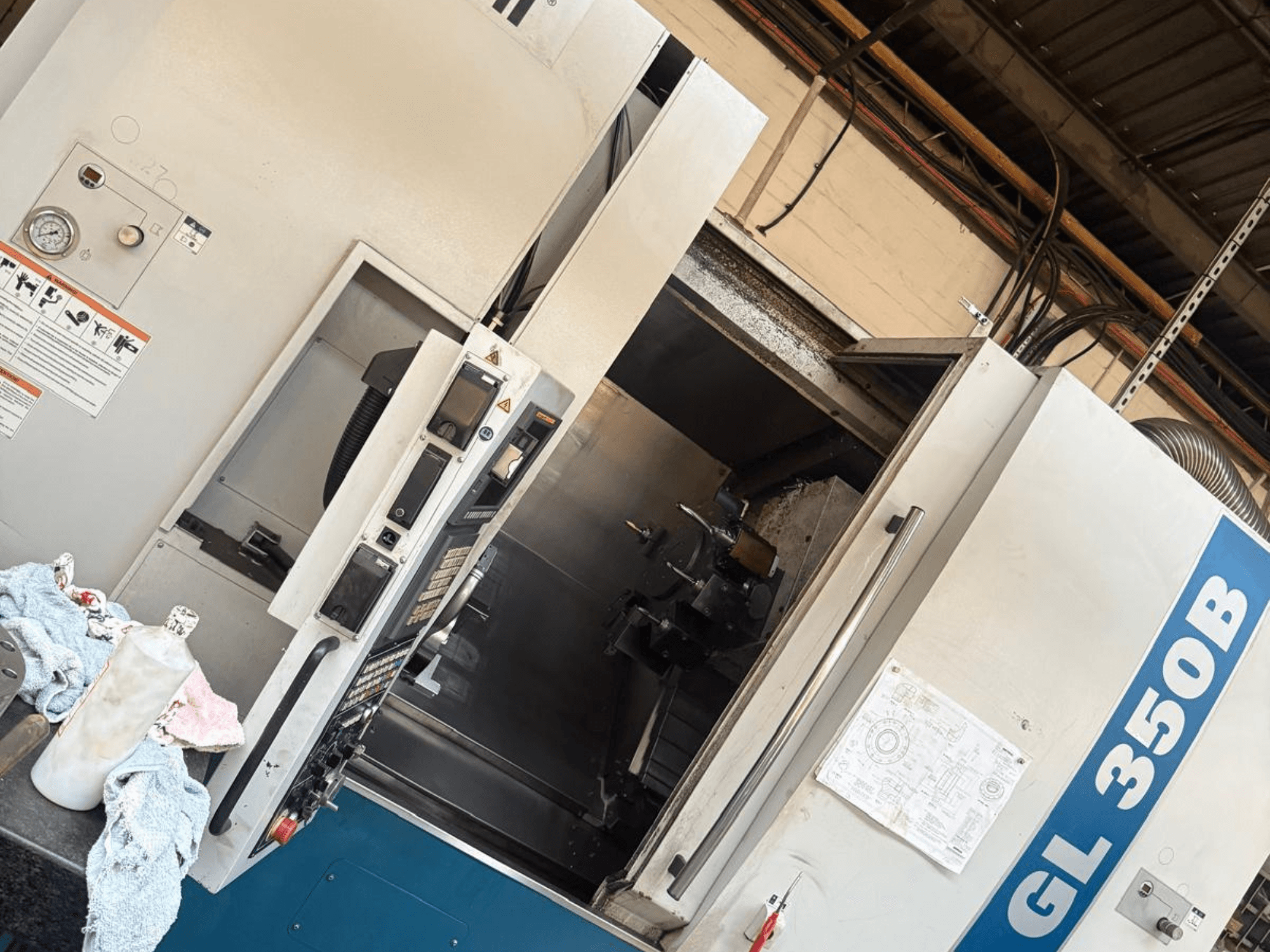 Horizontální soustruh Romi GL 350B, pohled zepředu, s ovládacím panelem a otevřenými dveřmi odhalujícími interiér.