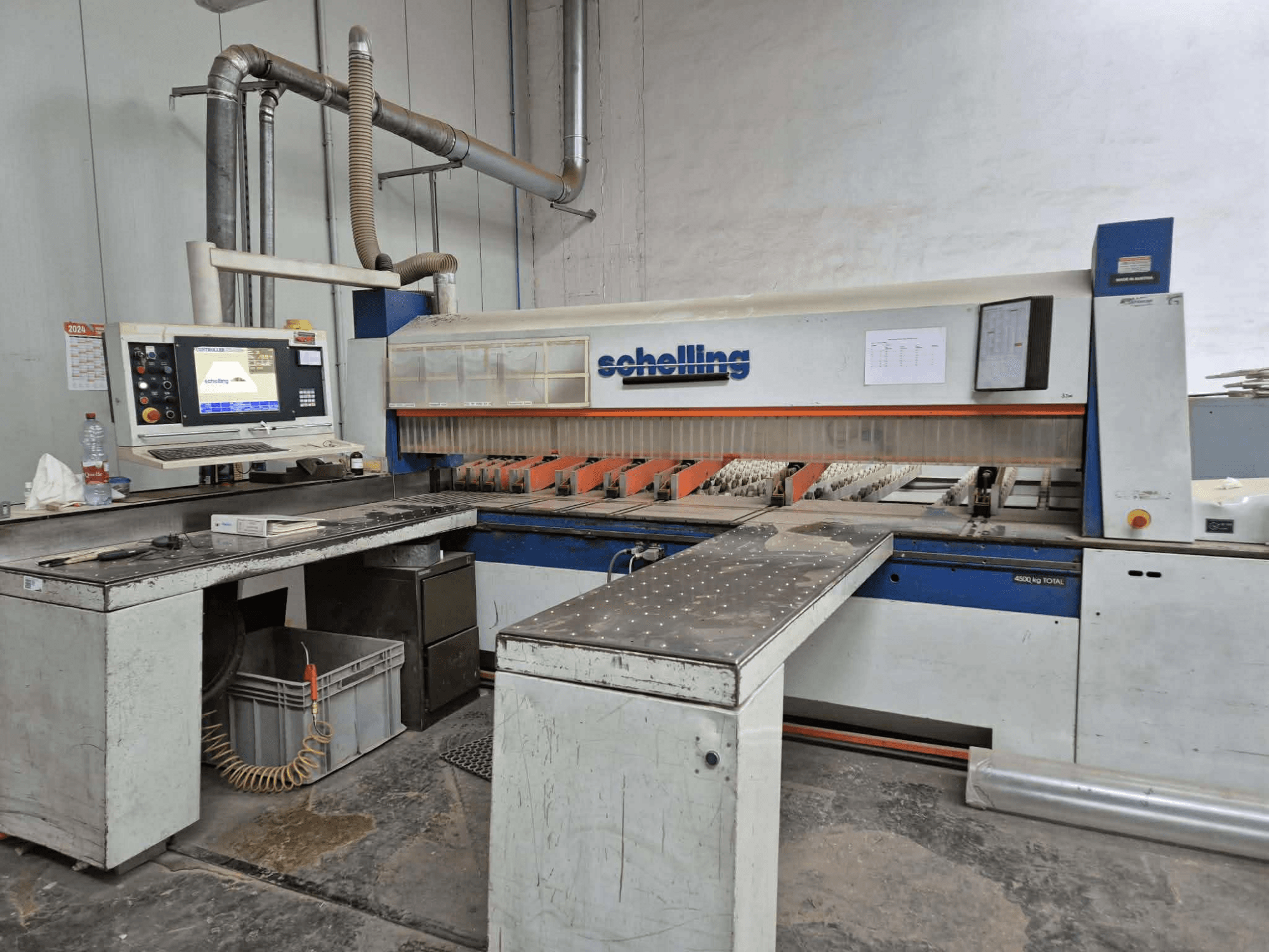 Řezací stroj Schaublin v bočním pohledu, vybavený počítačovým rozhraním, ostrými noži a robustní kovovou pracovní plochou.