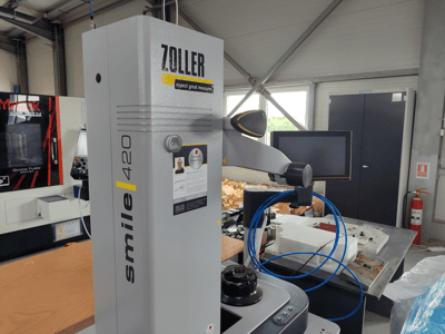 Měřicí zařízení ZOLLER smile 420 s monitorem, boční pohled v dílně, v pozadí modré hadice a stroje.