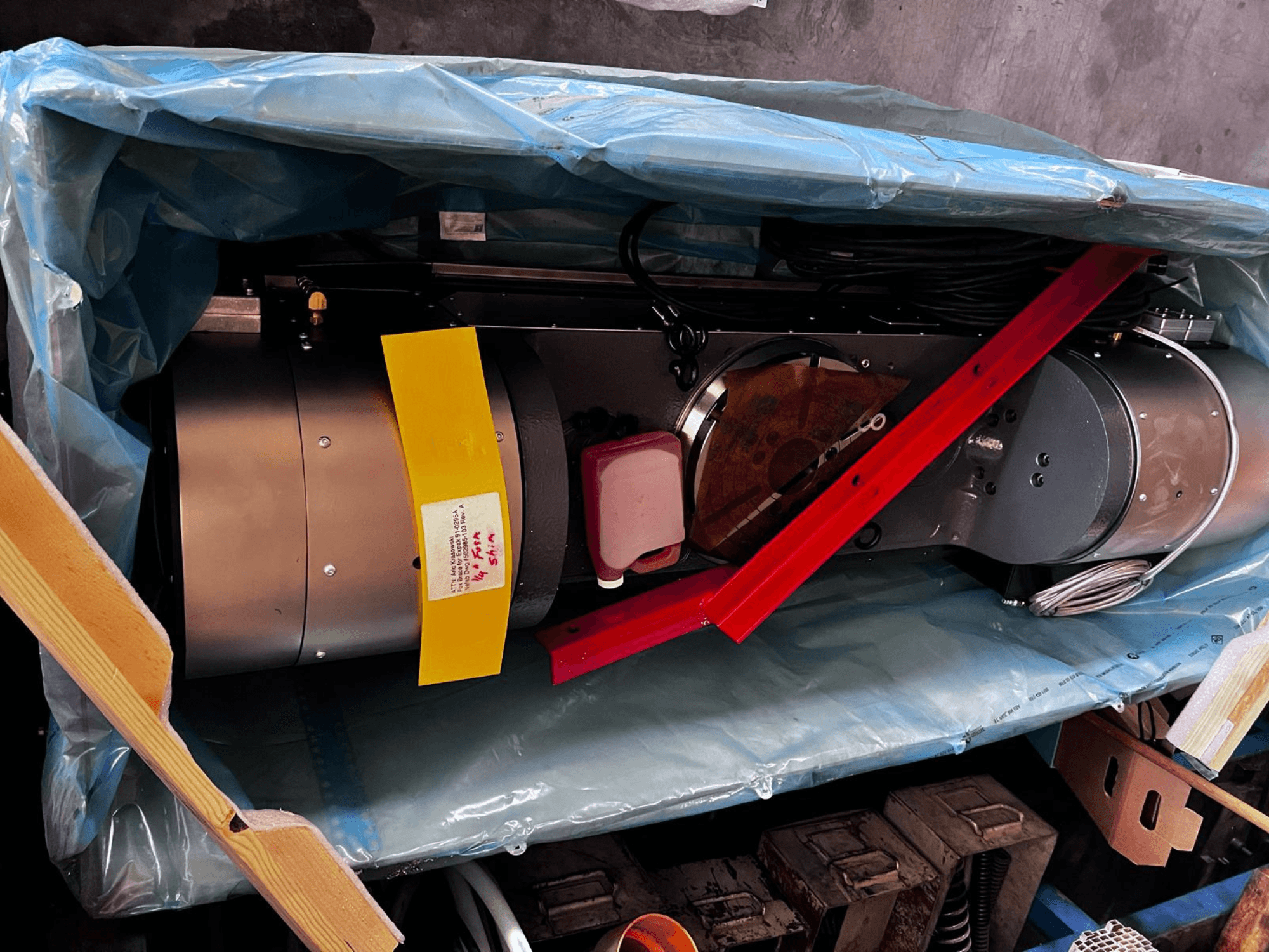 Motorové zařízení je částečně viditelné v obalu, má stříbrný exteriér, barevné ukazatele a červenou podpěru.