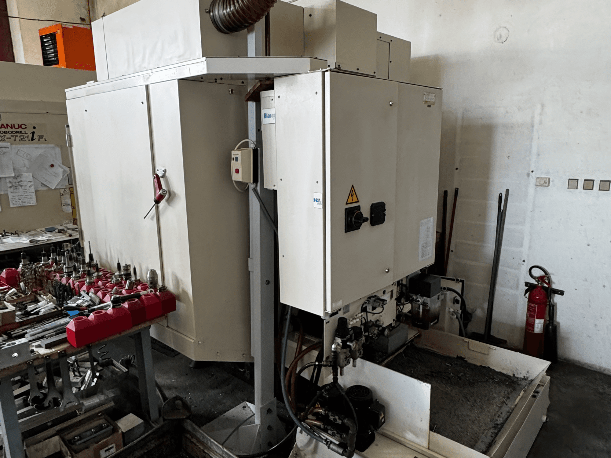 Vertikální obráběcí centrum FANUC Robodrill alpha-T21iFL, boční pohled zobrazující ovládací panel, nástroje a pracovní prostor.