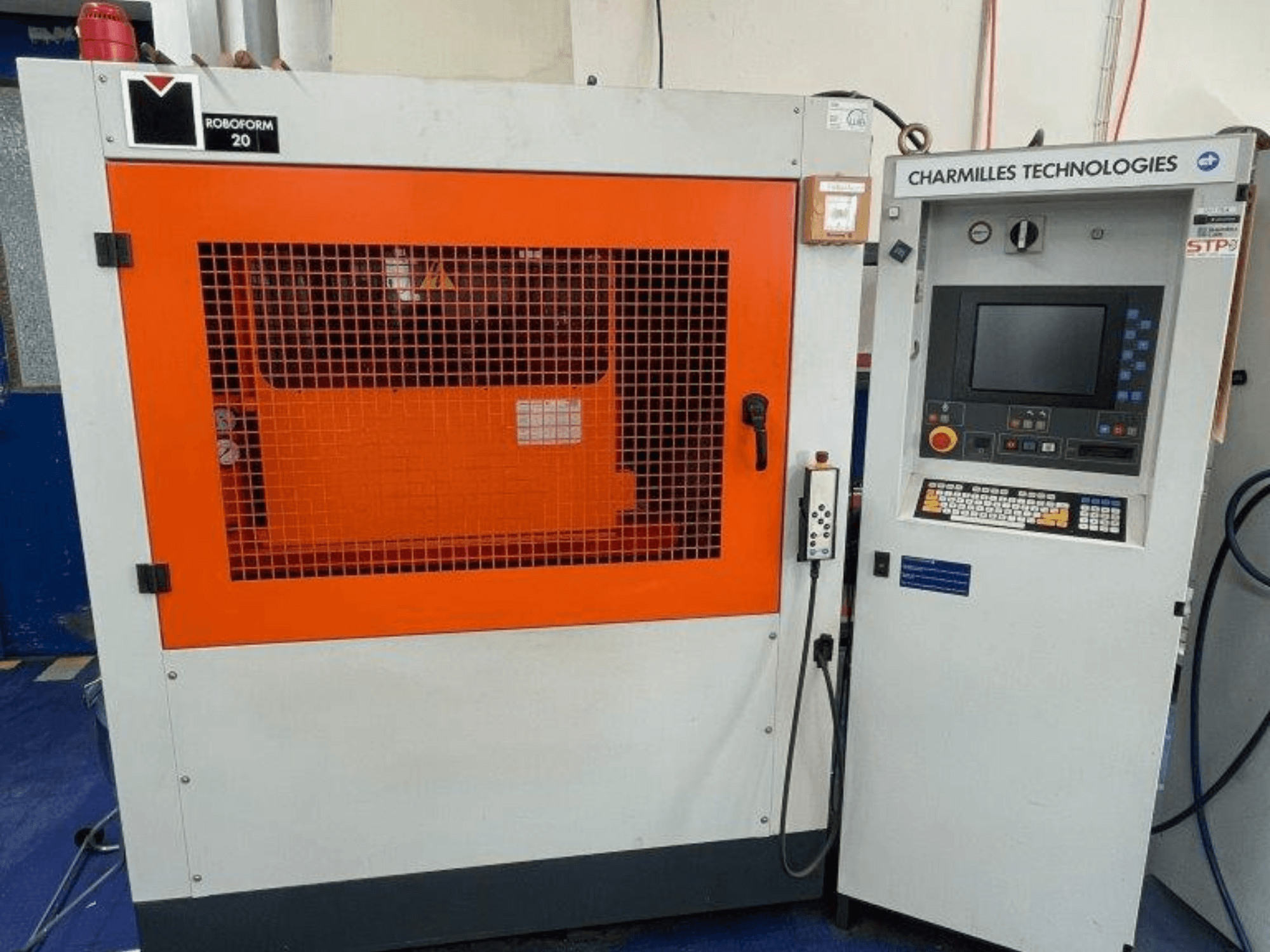 Hloubicí elektroerozivní stroj AgieCharmilles Robofrom 20, pohled zepředu s ovládacím panelem a oranžovou ochrannou mřížkou.