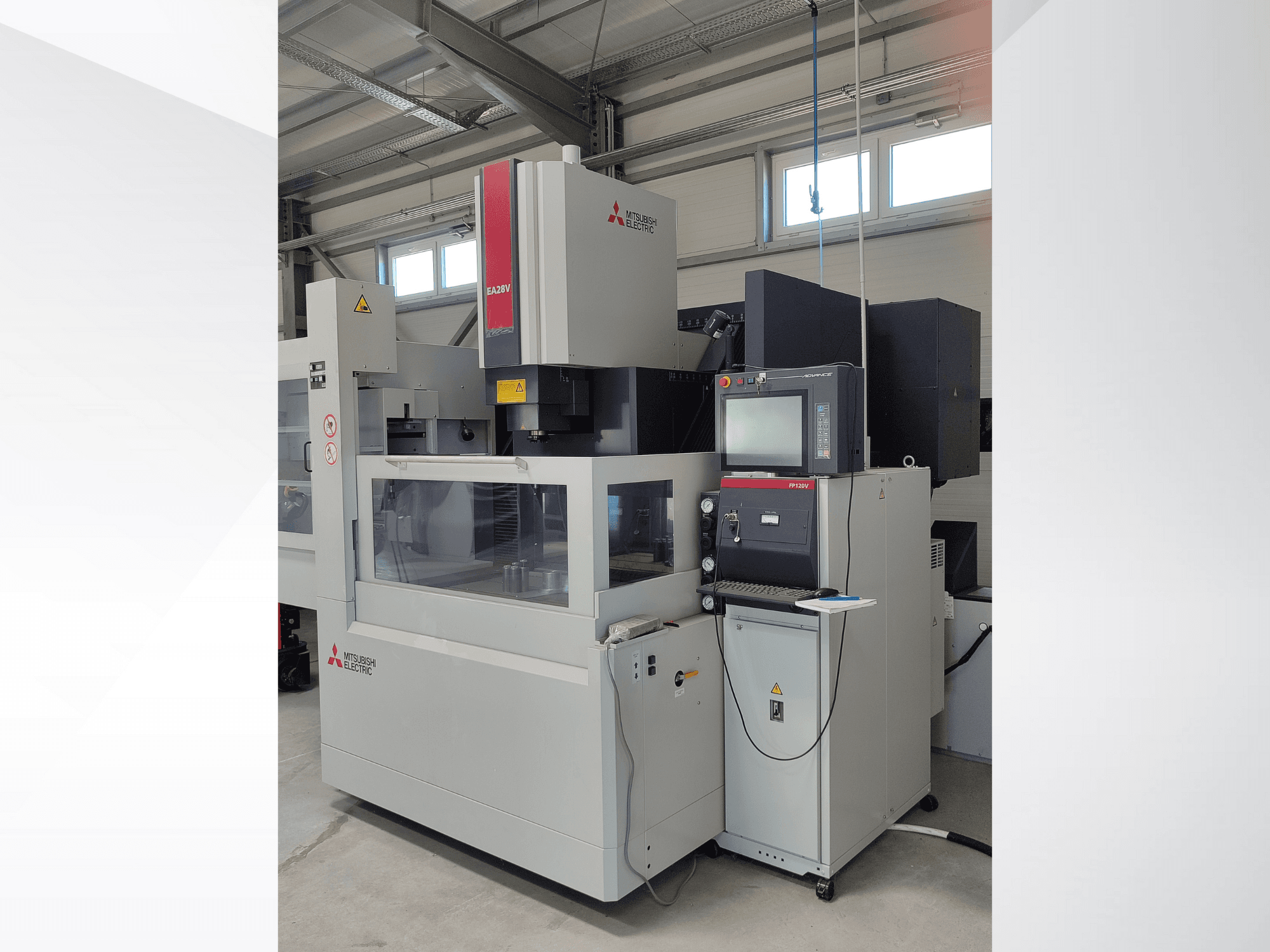 Drátový elektroerozivní stroj Mitsubishi Electric EA32V v bočním pohledu, s ovládacím panelem a viditelným pracovním prostorem přes sklo.