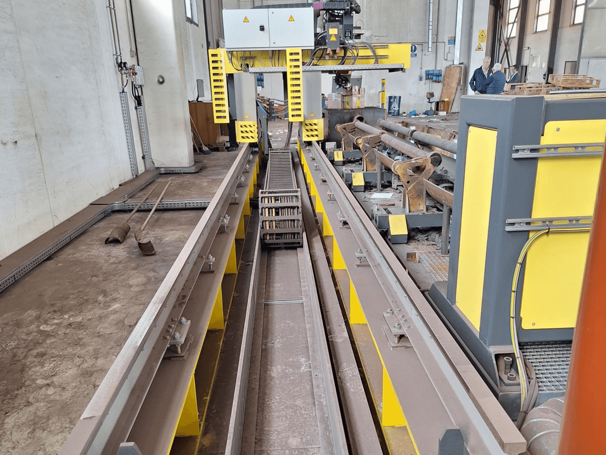 Stroj na řezání trubek ESAB SUPRAREX 3100 SXE HD 1000 při pohledu zepředu, s pásy, řezací hlavou a žlutými bezpečnostními prvky.