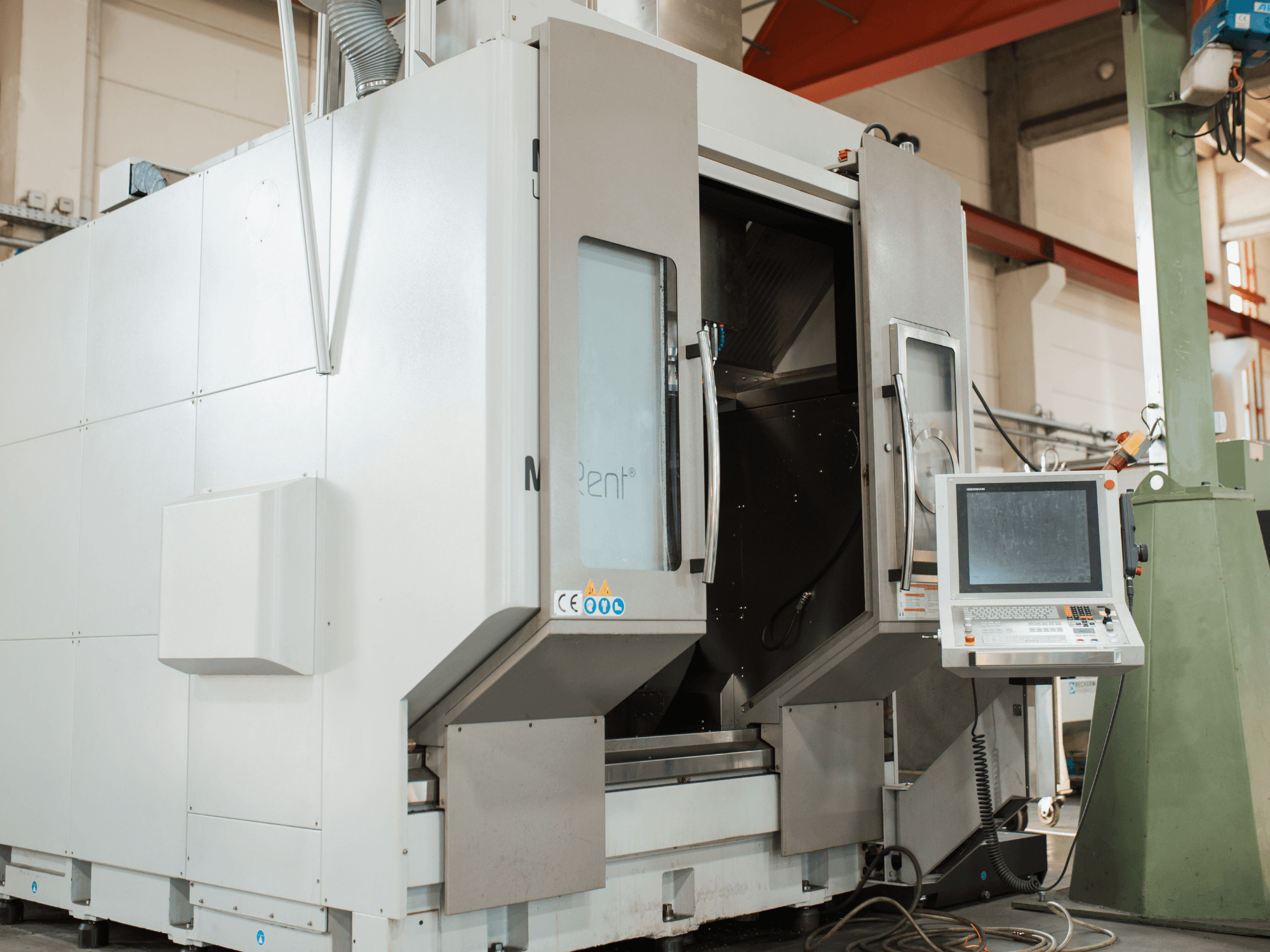 N Rent® CNC frézka, pohled zepředu, má ovládací panel s obrazovkou, otevřené dveře a průmyslové prostředí.