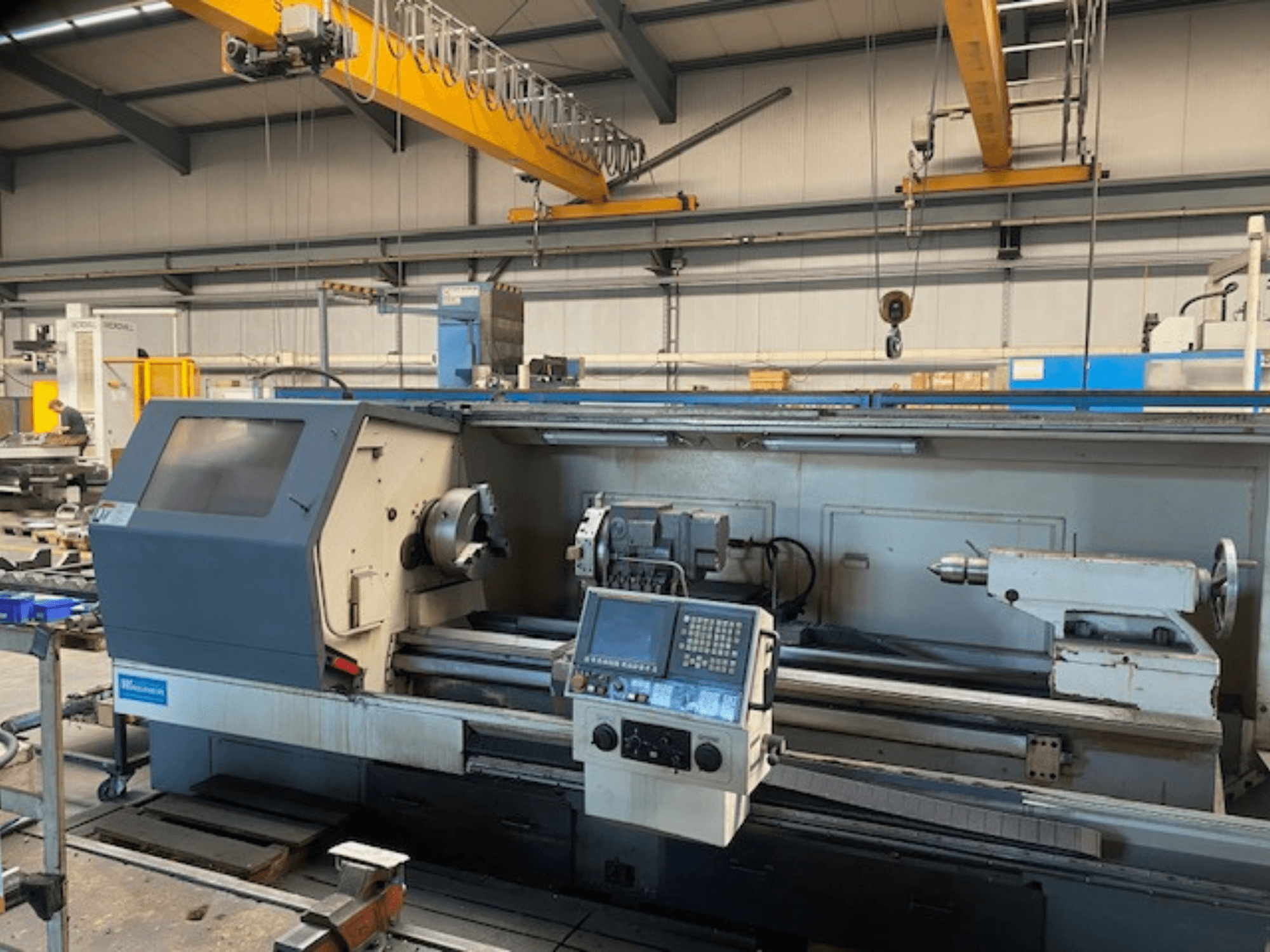 Přesný soustruh Wabeco, pohled zepředu s ovládacím panelem, který ukazuje nastavení vřetena a nástrojů v továrním prostředí.