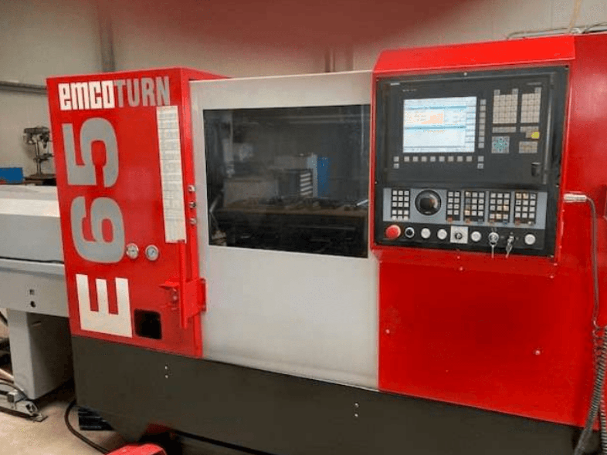 CNC soustruh EMCO Turn E65, čelní pohled zobrazující ovládací panel, velký displej a pracovní plochu za sklem.