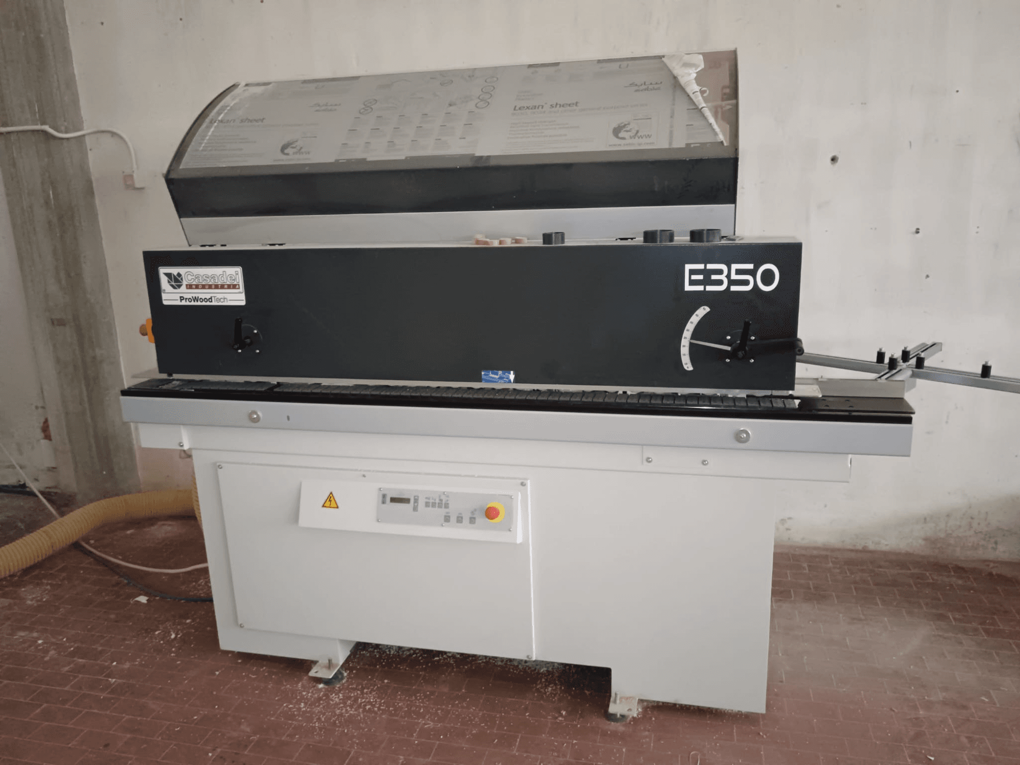 Cesaroli ProWoodtech E350, boční pohled na dřevoobráběcí stroj s ovládacím panelem a akumulací prachu, namontovaný na bílém podstavci.