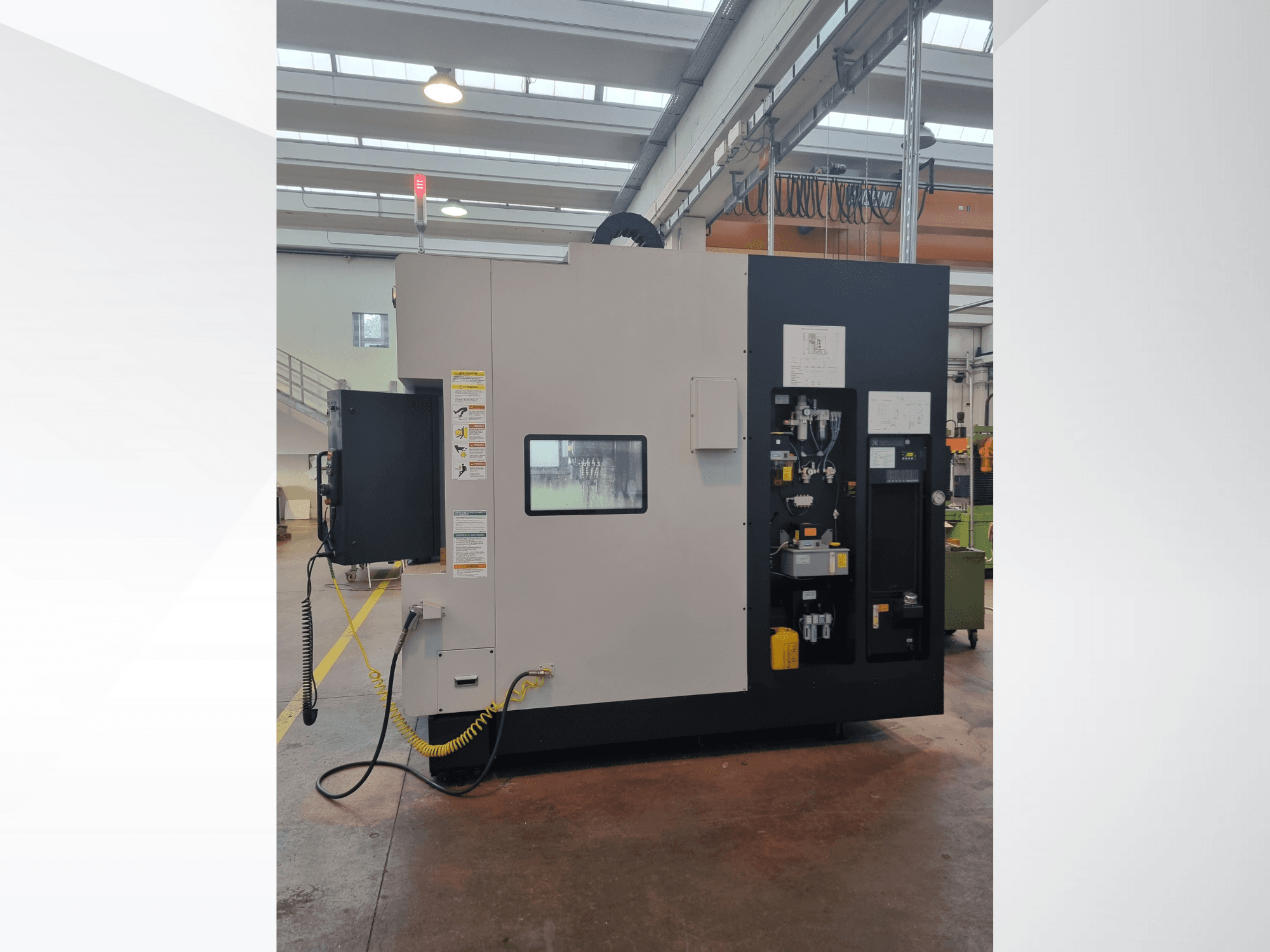 Průmyslový stroj z bočního pohledu s ovládacím panelem s tlačítky, indikátory a bezpečnostním výstražným štítkem.