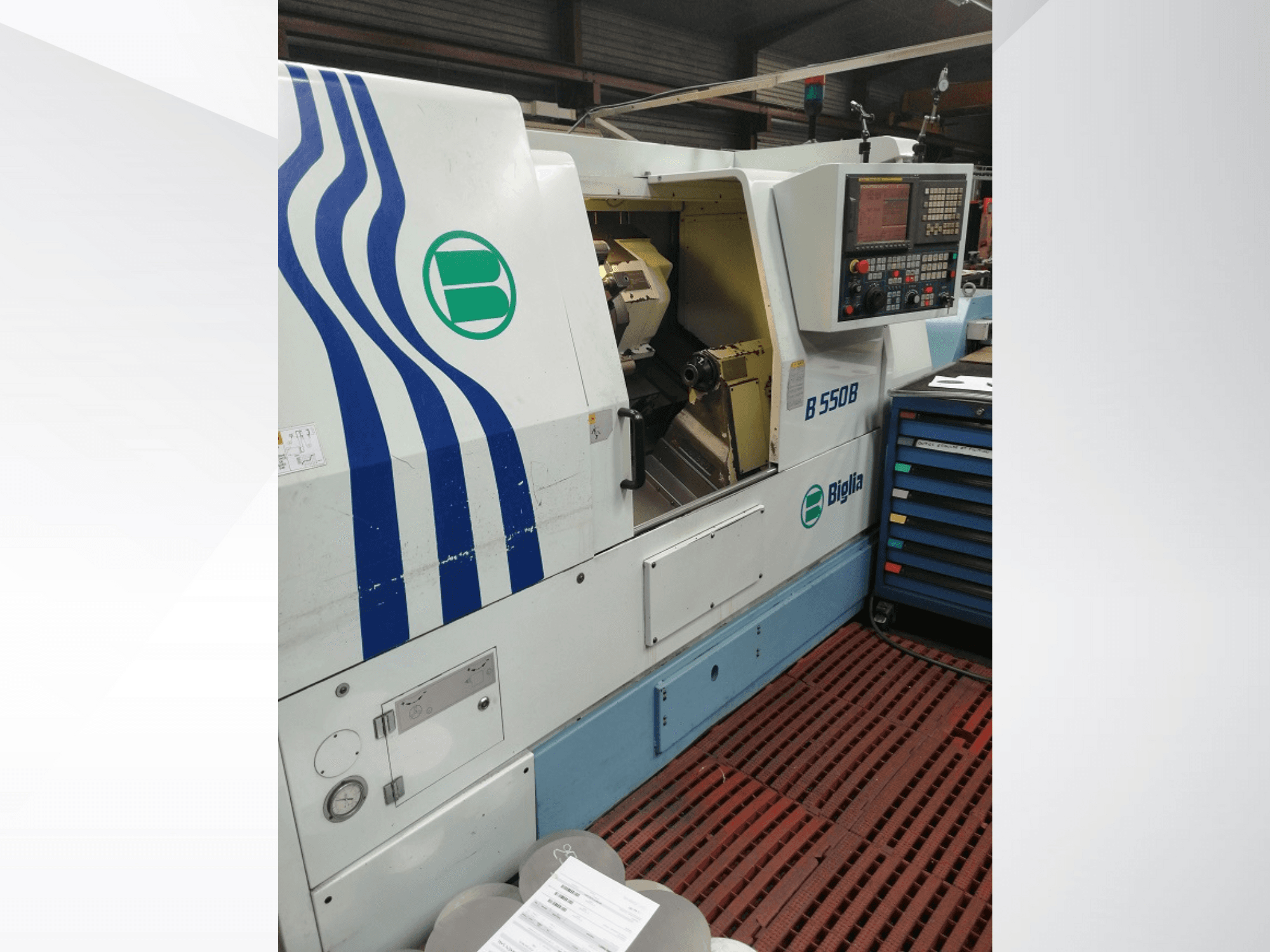 Soustruh Biglia B 550 B CNC zobrazený zepředu, s ovládacím panelem, kovovým prostorem a barevným úložným prostorem pro nástroje.