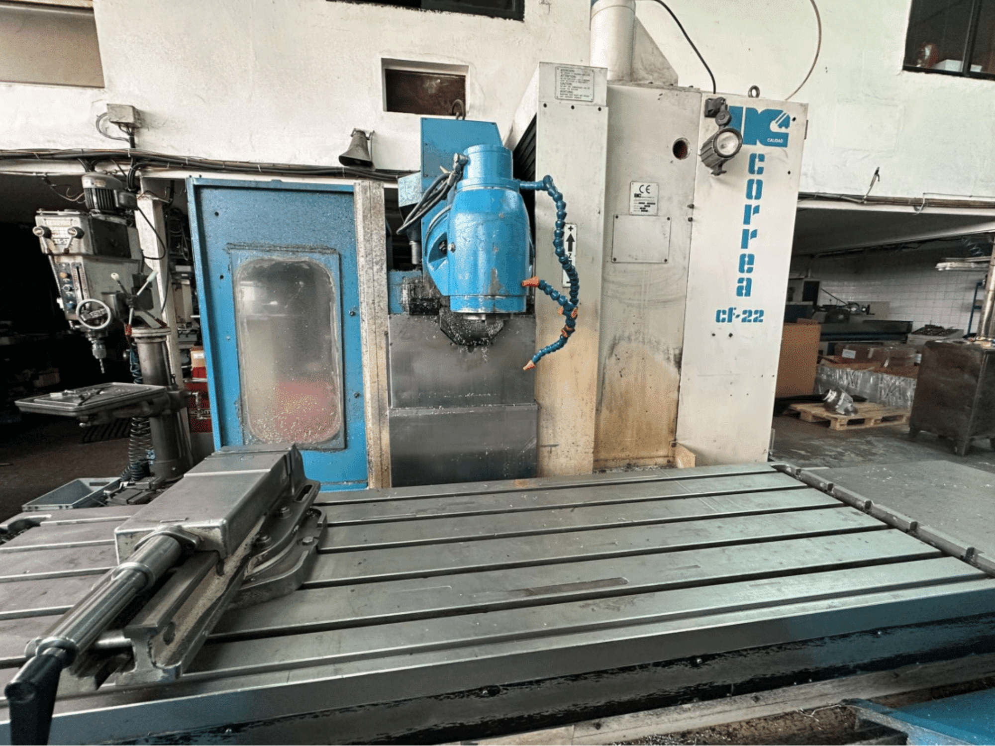 Frézka Correa CF-22, pohled zepředu; má kovový pracovní stůl a modrobílý ovládací panel s knoflíky.