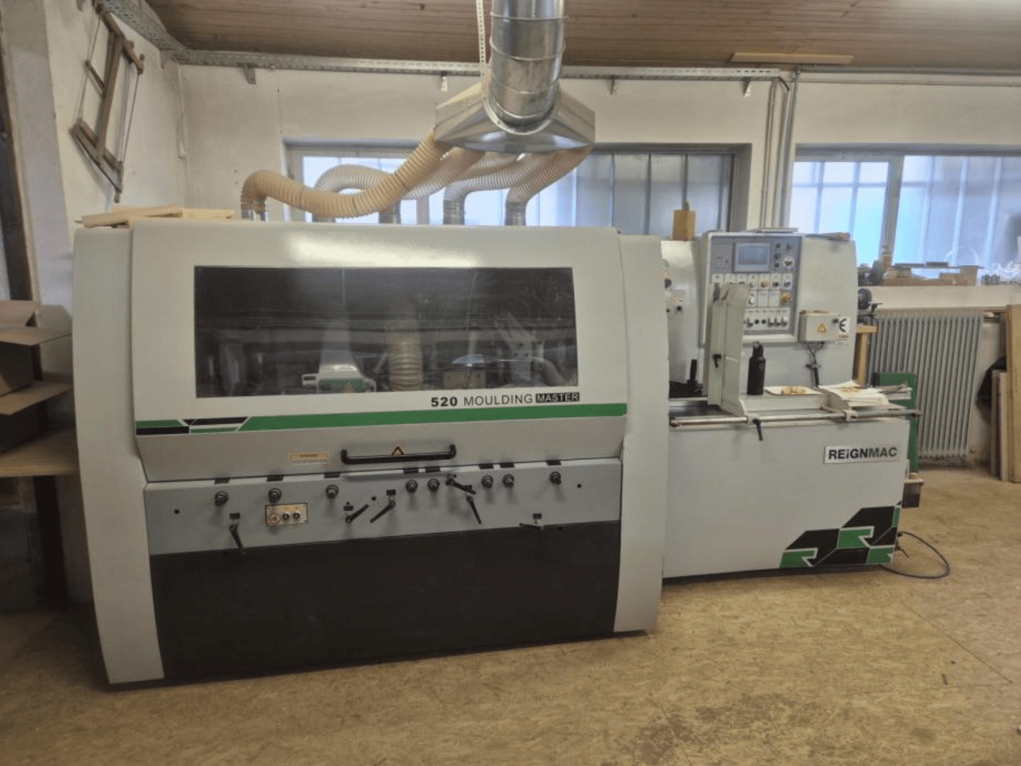 Pohled na hoblovku REIGNMAC 520 MOULDING MASTER zepředu, ovládací panel, podávací válce a systém odsávání prachu.