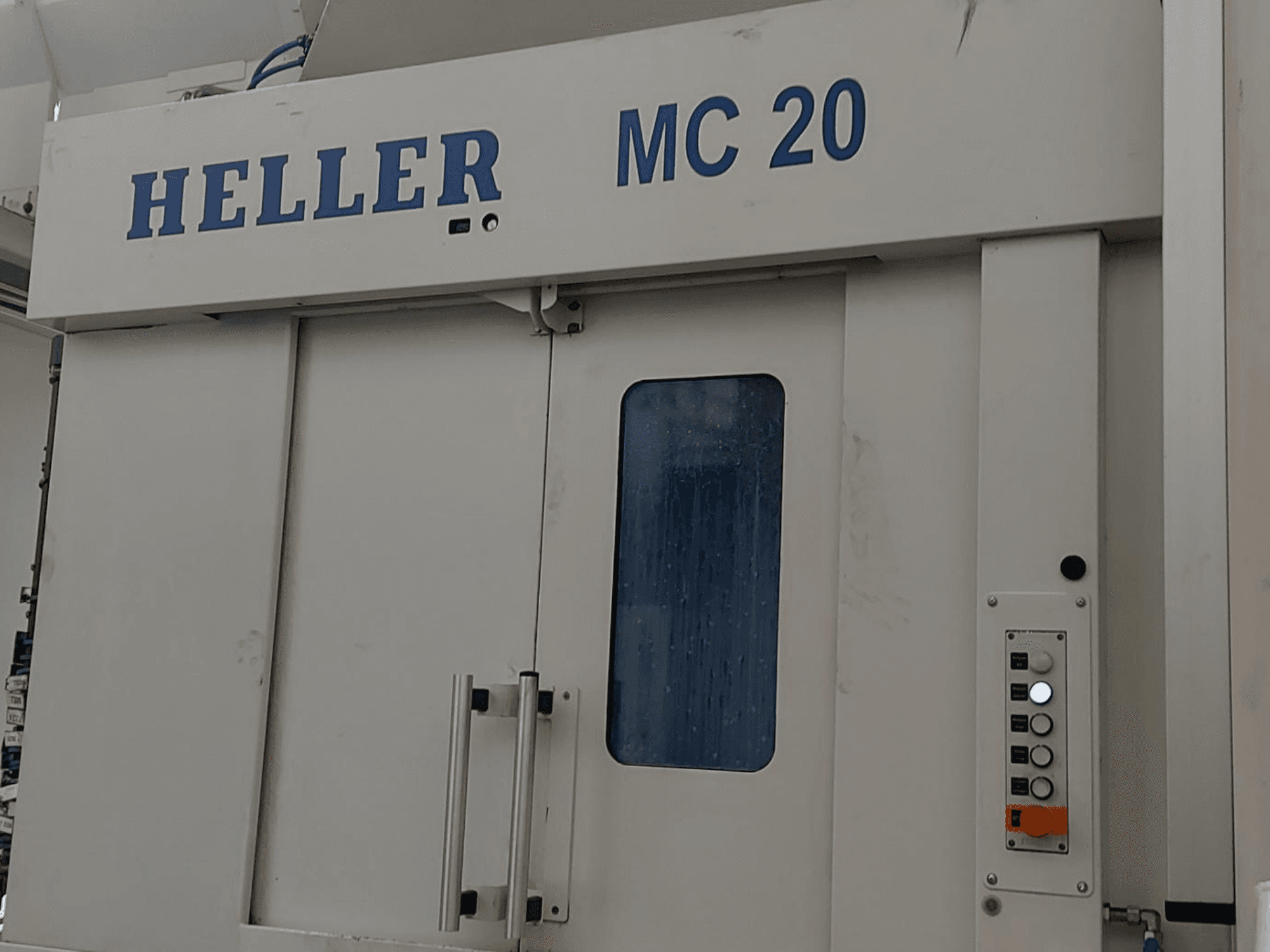 Pohled zepředu na horizontální obráběcí centrum HELLER MC 20 s ovládacím panelem a čelním oknem.