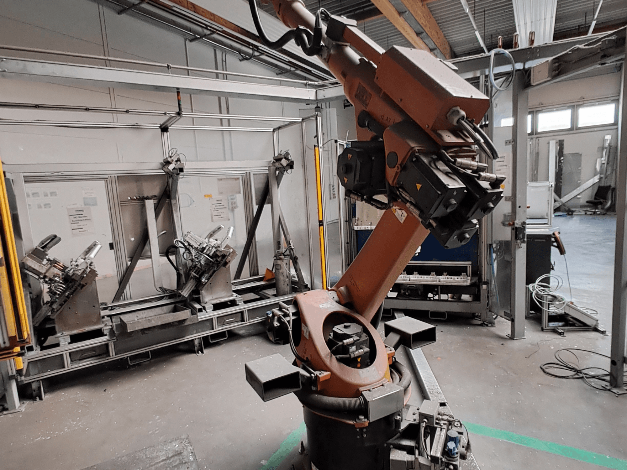 Robotické rameno KUKA KR 30L16-2 v průmyslovém prostředí, pohled z boku, znázorňující klouby ramene a uchopovací nástroje.