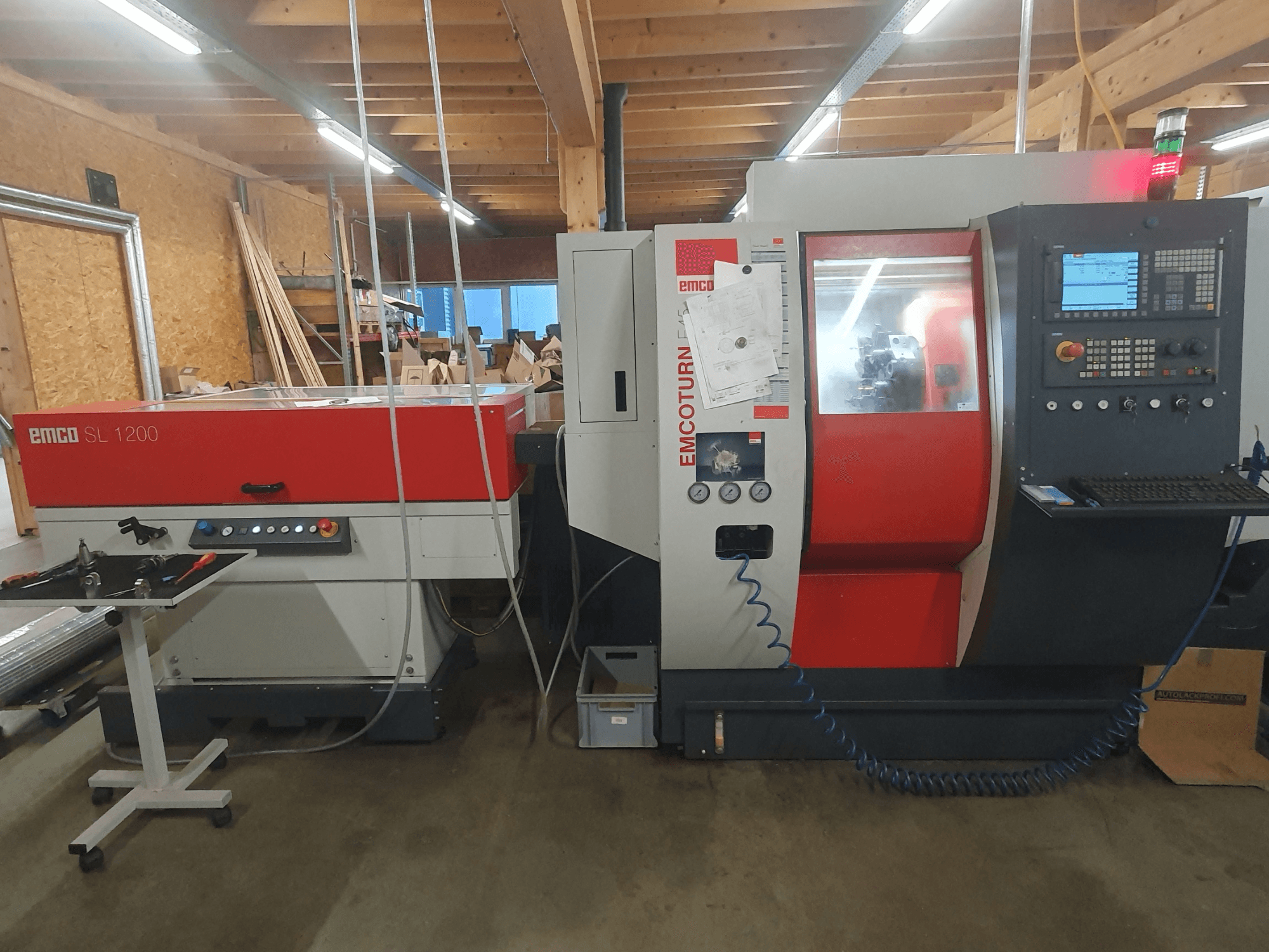 CNC soustruh EMCO SL 1200 a EMCOturn; čelní pohled zobrazující ovládací prvky, displeje a provozní ukazatele v dílenském prostředí.