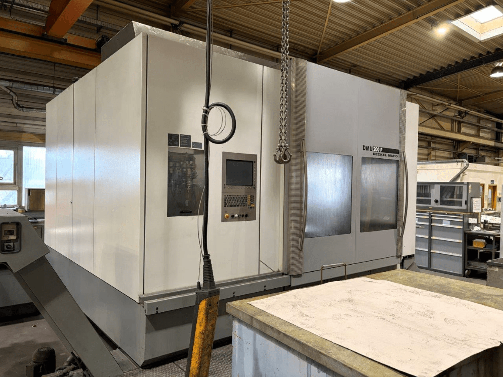 Univerzální obráběcí centrum DMG MORI DMU 200 v dílně, pohled zepředu, kde je vidět jeho ovládací panel a vnější prvky.