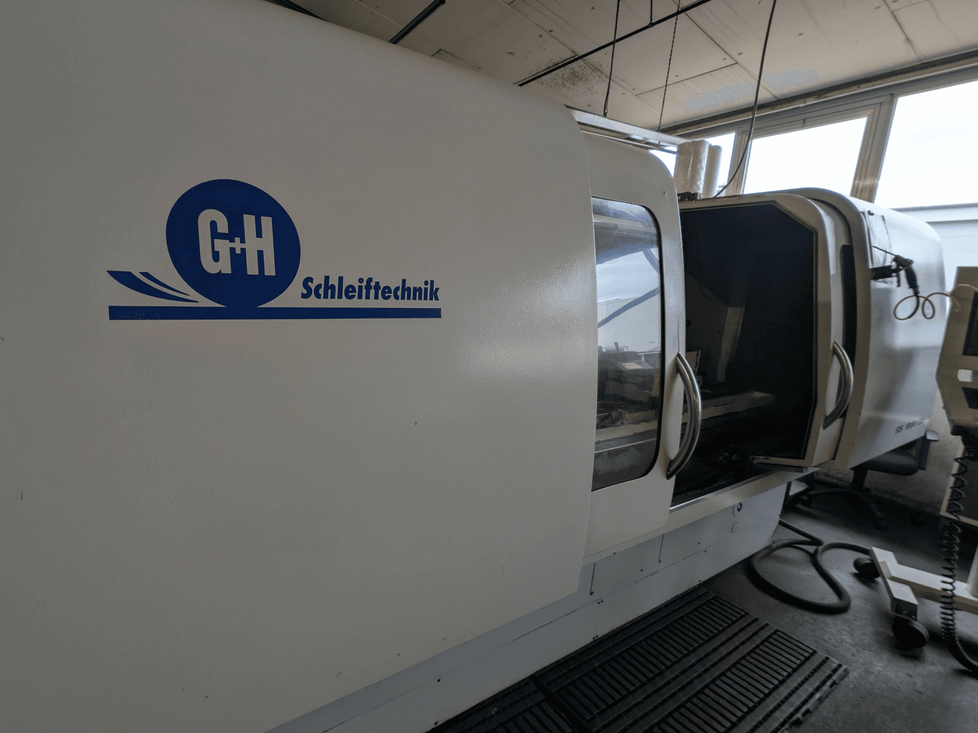 Bruska na kulato GEIBEL & HOTZ RS 1000 CU, boční pohled na ovládací panel a otevřené přístupové dveře.