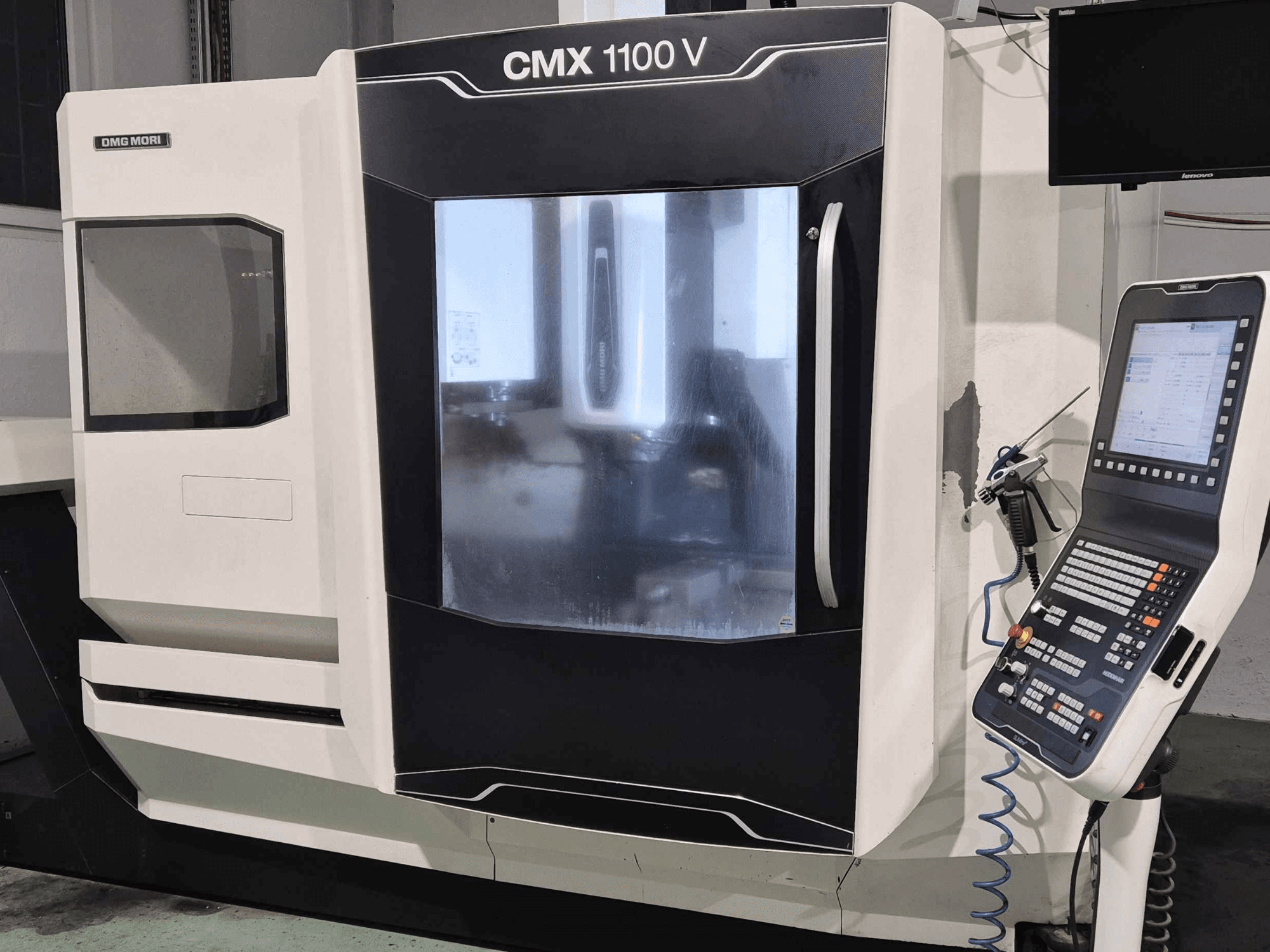 DMG Mori CMX 1100 V, čelní pohled na CNC stroj s viditelným ovládacím panelem, digitálním displejem a nastavením chladicí kapaliny.