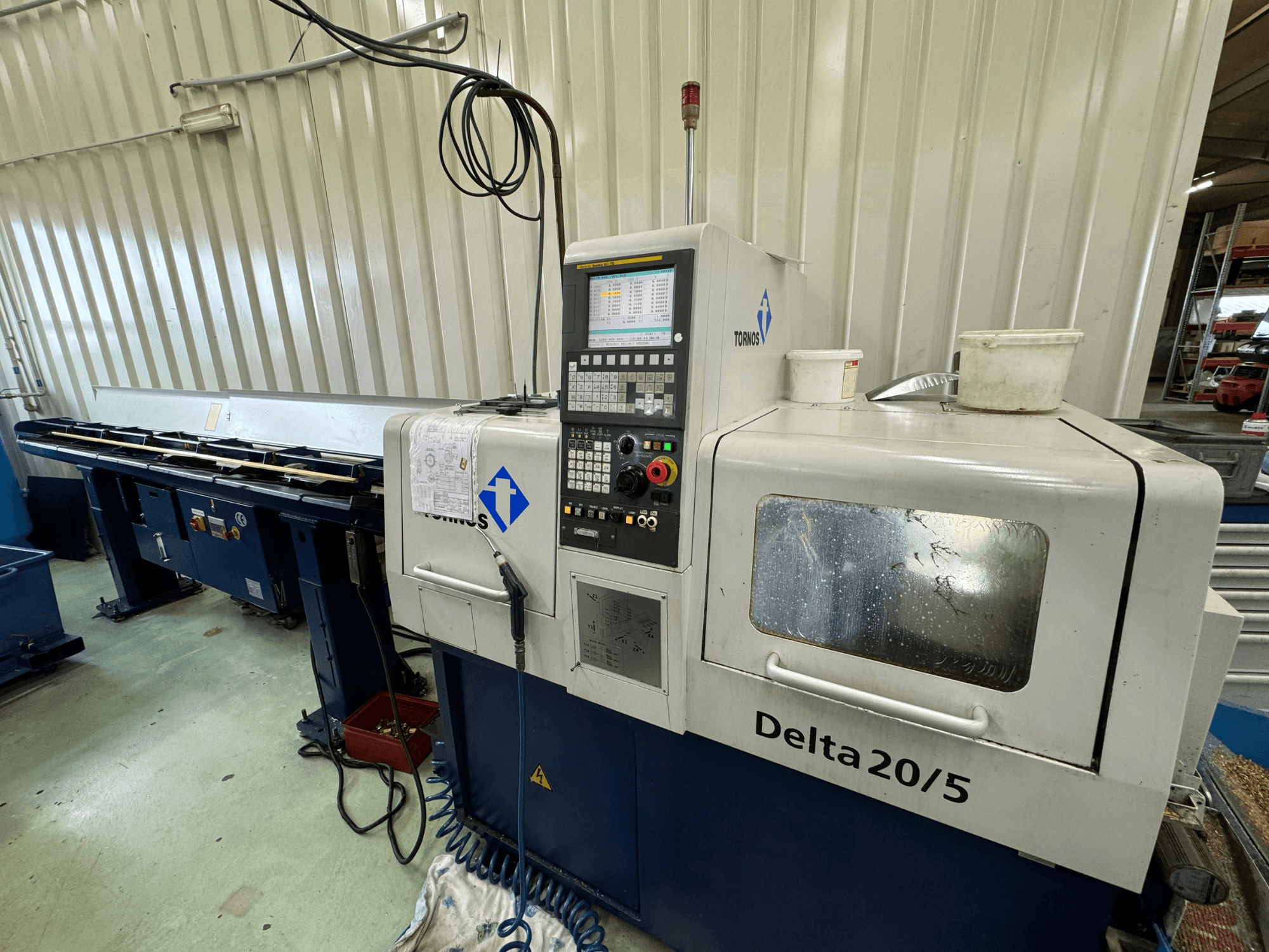 CNC stroj Torino Delta 20/5, pohled zepředu, s ovládacím panelem a pracovním prostorem. Leptané sklo a viditelná kabeláž.