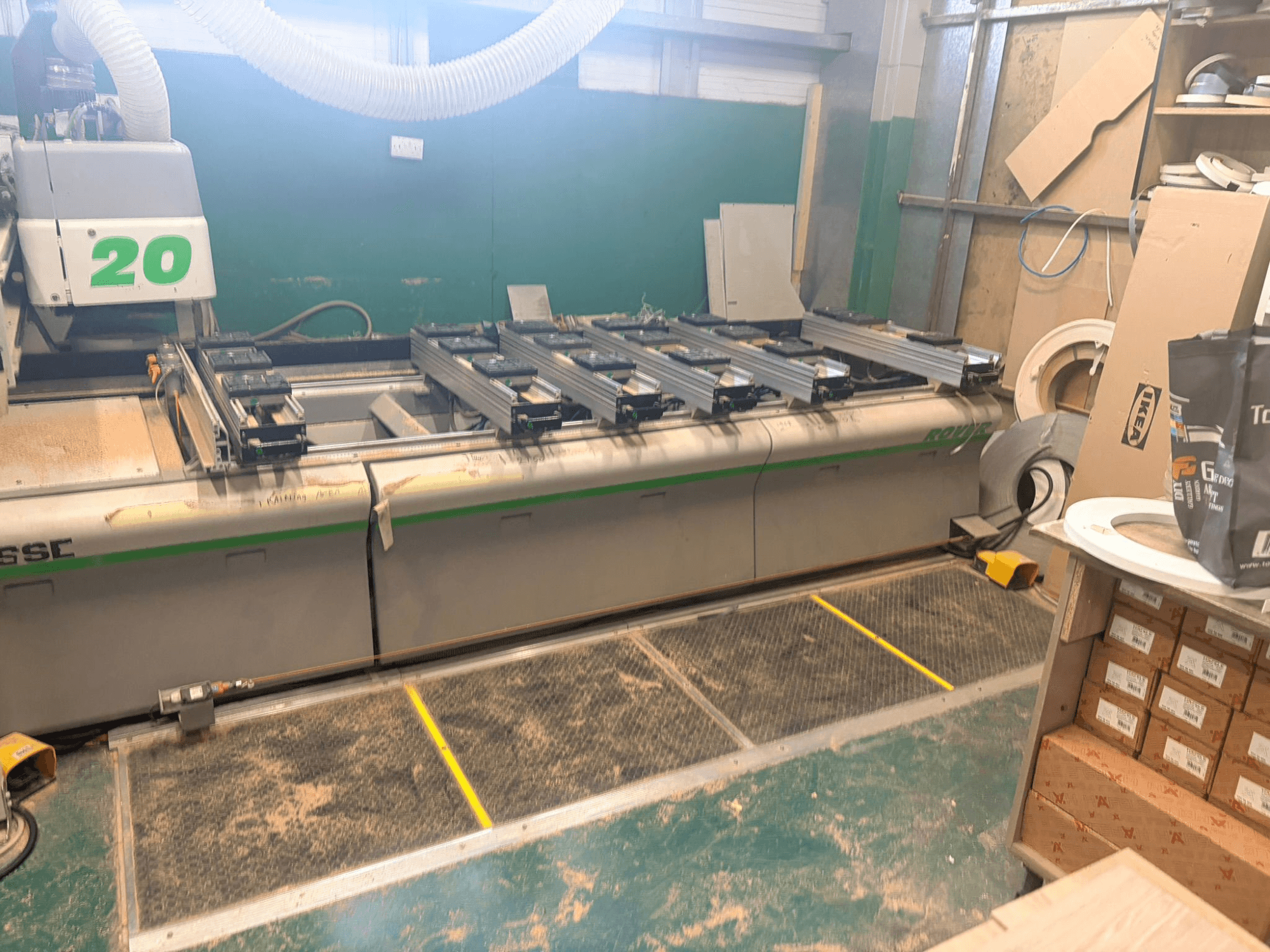 CNC obráběcí centrum na dřevo BIESSE ROVER 20, pohled zepředu, s kolejnicovým systémem, ovládacími prvky a viditelnými pilinami na povrchu.
