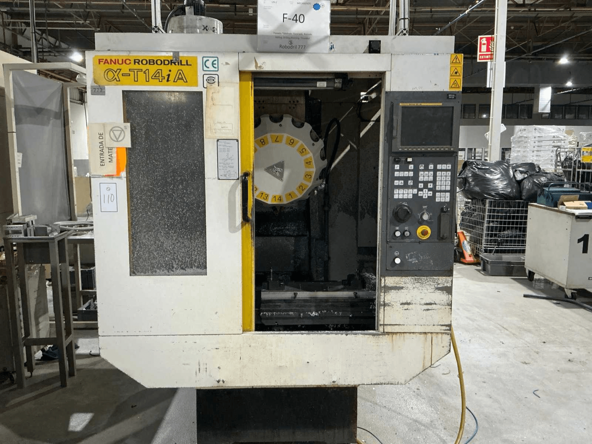 Vertikální obráběcí centrum FANUC ROBODRILL α-T14iB, čelní pohled na ovládací panel a karusel nástrojů.