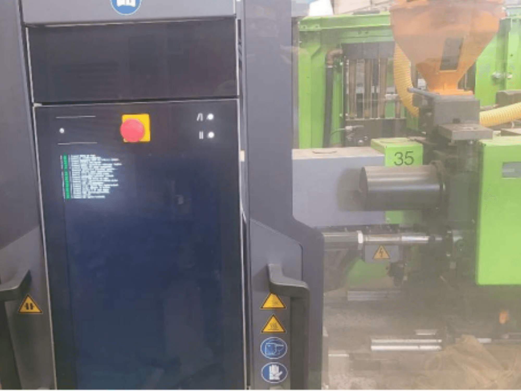 Hydraulický vstřikovací stroj Engel Victory 320/80 spex, pohled zepředu ukazuje ovládací panel a zelenou vstřikovací jednotku.