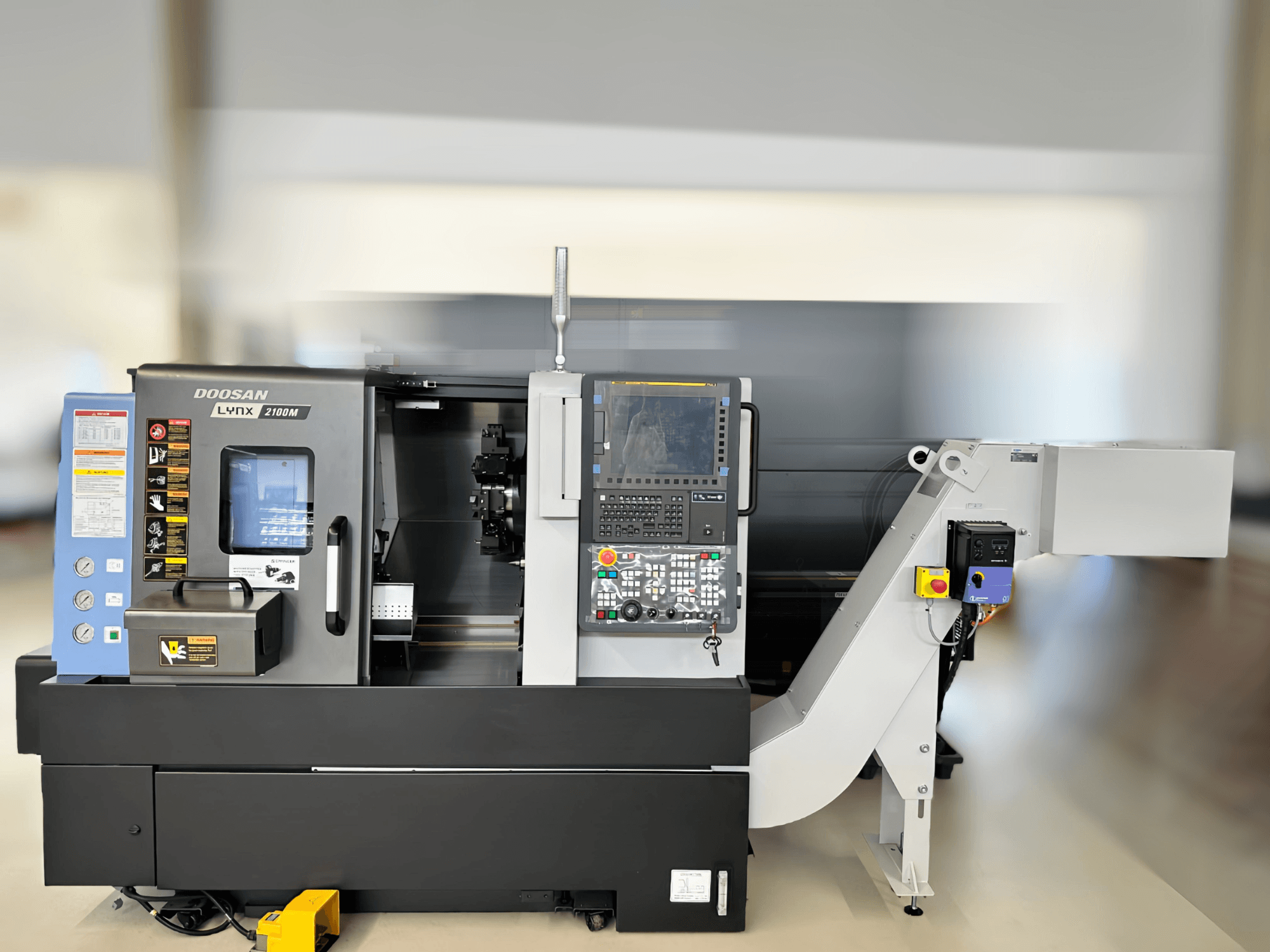Pohled zepředu na horizontální soustruh DN SOLUTIONS LYNX 2100MB, zobrazující ovládací panel a detaily pracovního prostoru.