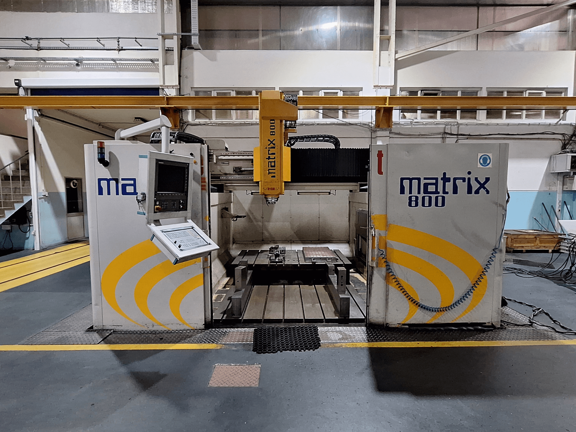 Portálová frézka Breton Matrix WM 800 K25 v dílně, pohled zepředu na ovládací panel a pracovní stůl.