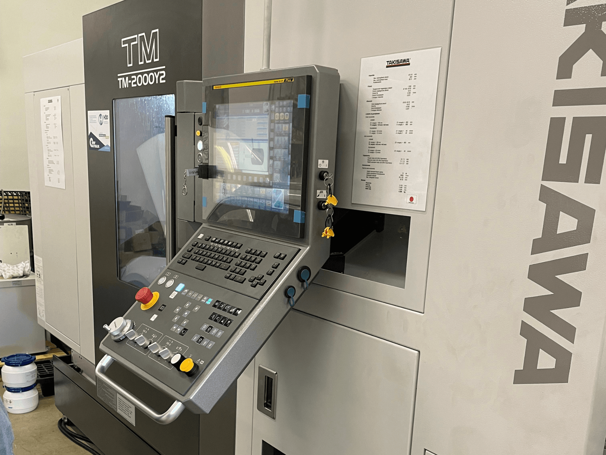 Ovládací panel horizontálního soustruhu Takisawa TM-2000Y2 z čelního pohledu, s digitálním displejem a ovládacími tlačítky.