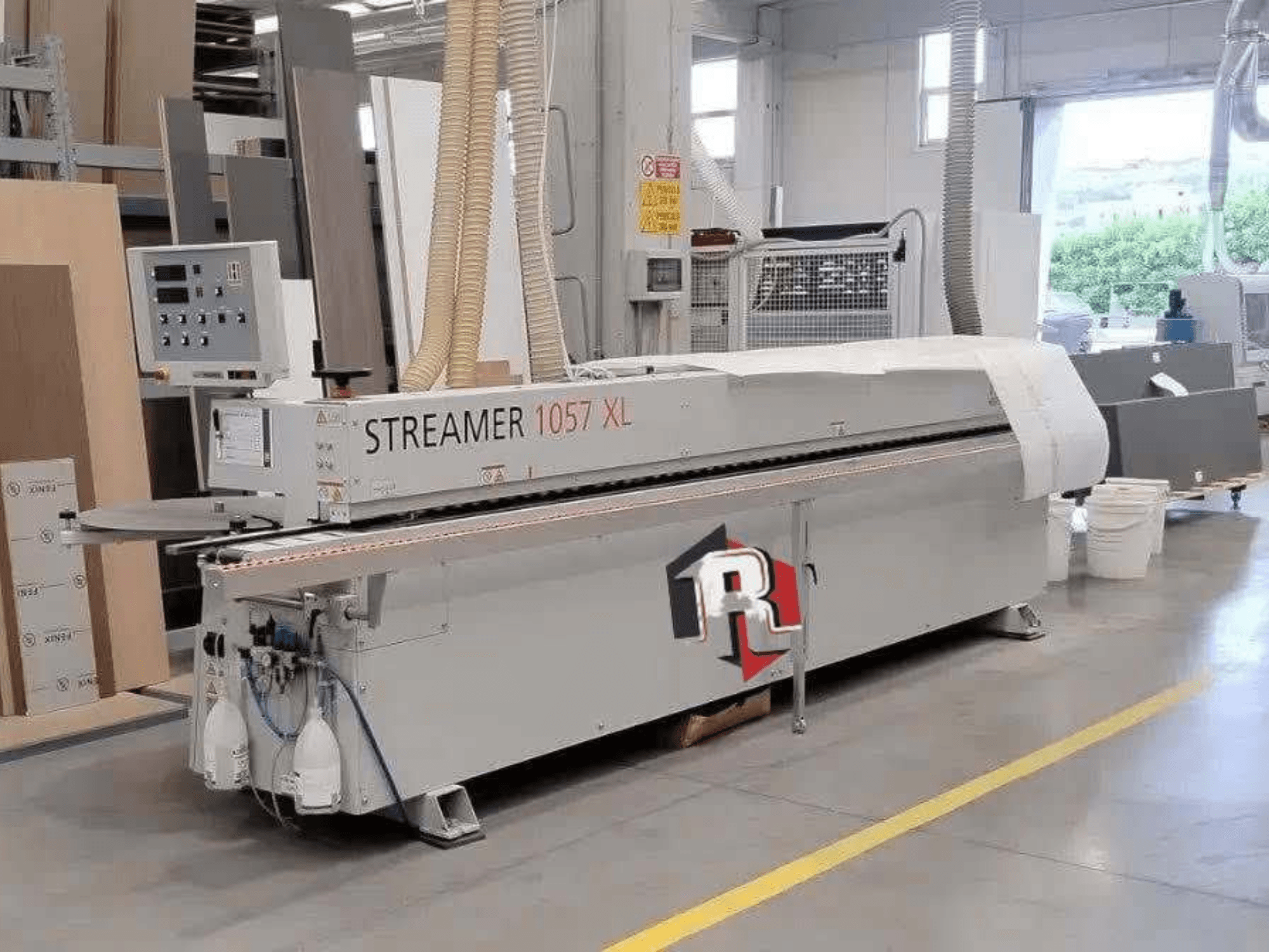 Olepačka hran HOLZHER STREAMER 1057 XL v dílně, boční pohled s viditelným ovládacím panelem a vzduchovými hadicemi.