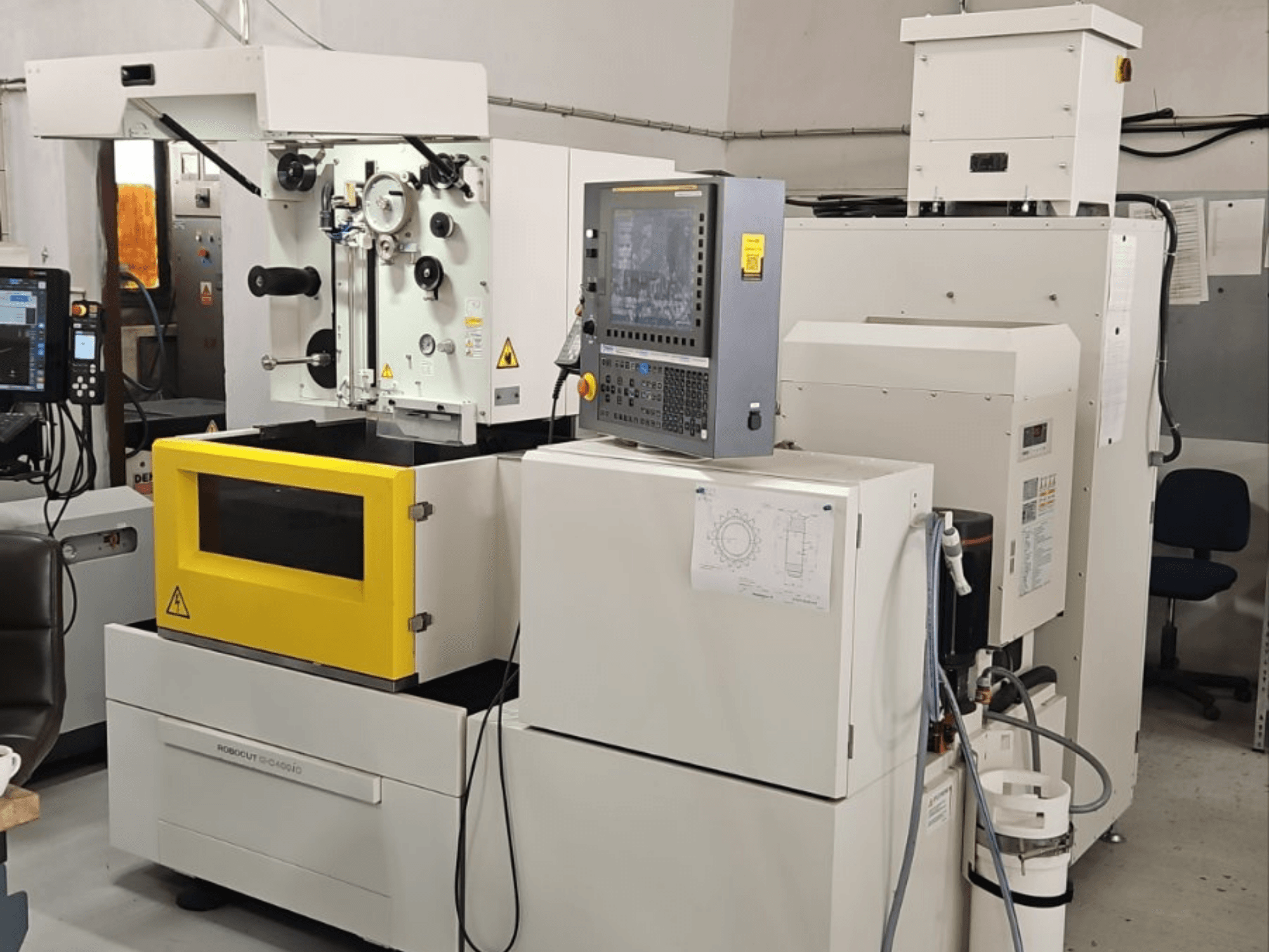 Drátová elektroerozivní frézka FANUC Robocut alpha C400iC, pohled zepředu s ovládacím panelem a žlutou pracovní komorou.