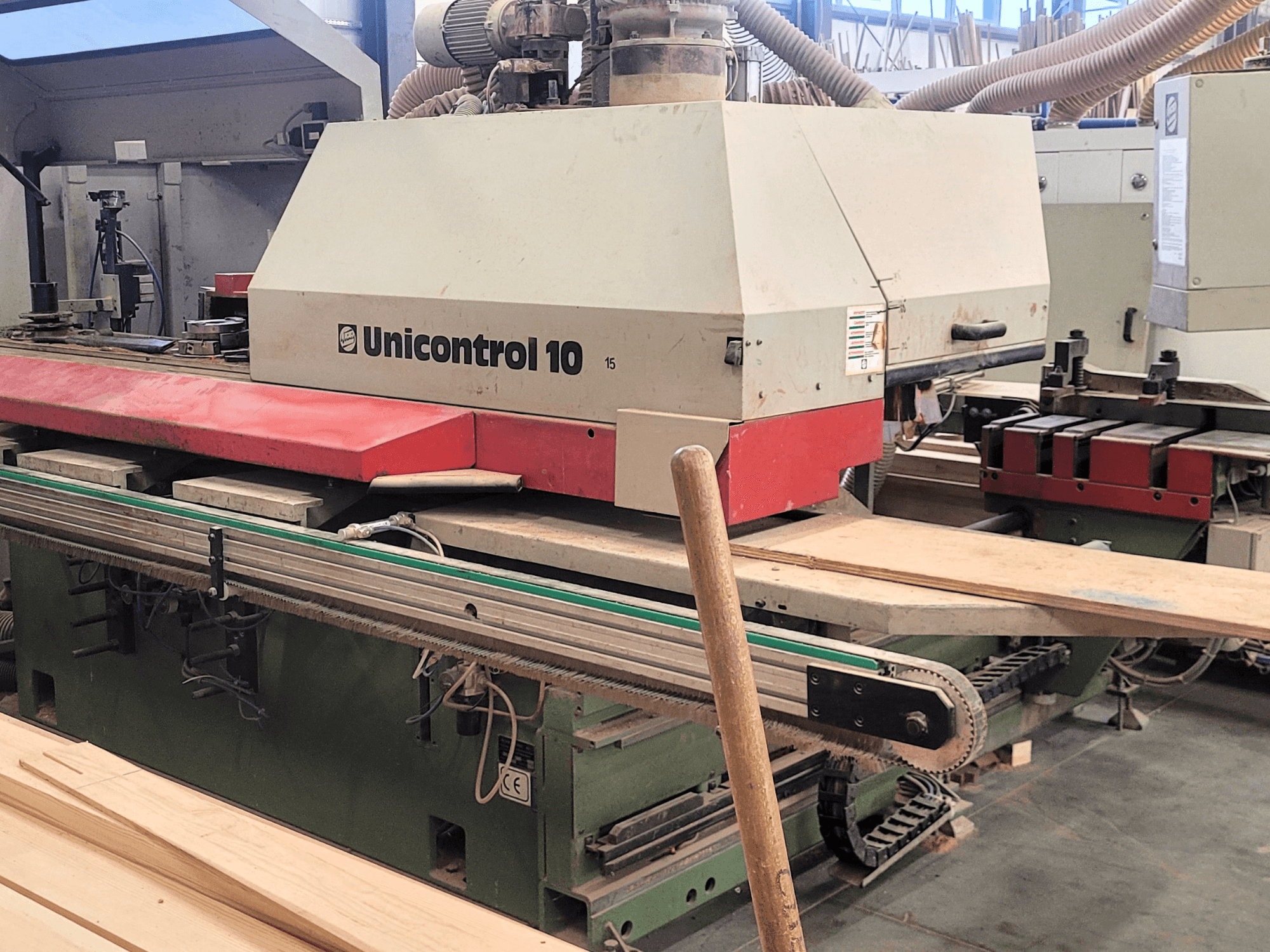 CNC obráběcí centrum Unicontrol 10 od WEINIG/DIMTER, čelní pohled s dřevěnými deskami a zařízením v dílně.