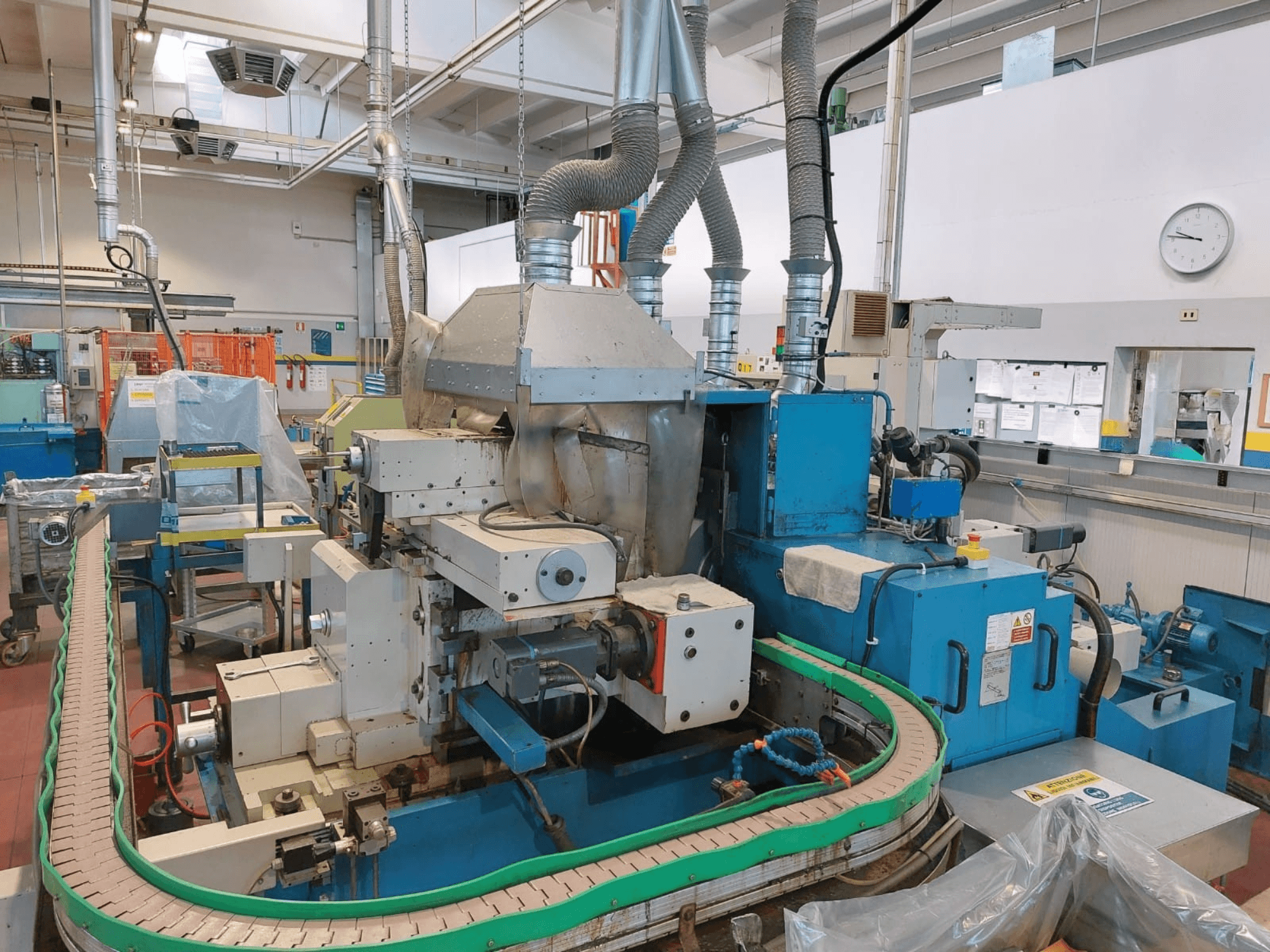 GHIRINGHELLI M300SP610 CNC3A bezhrotá bruska, pohled zepředu, na které jsou vidět složité detaily strojního zařízení a dopravníku.