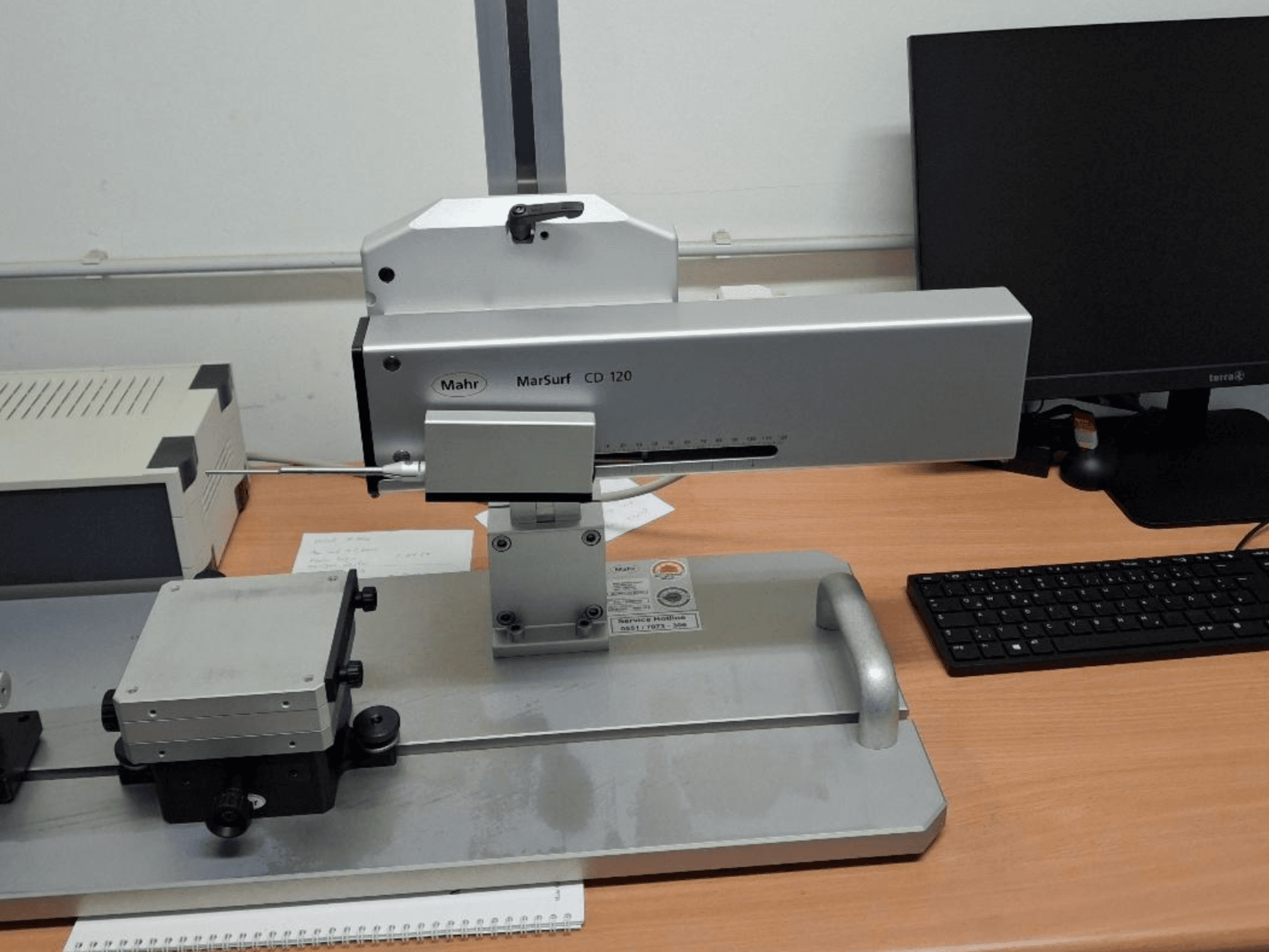 Souřadnicový měřicí stroj Mahr MARSURF CD 120 při pohledu zepředu, ukazuje měřicí hlavu, ovládací panel a namontovaný měřicí stůl.