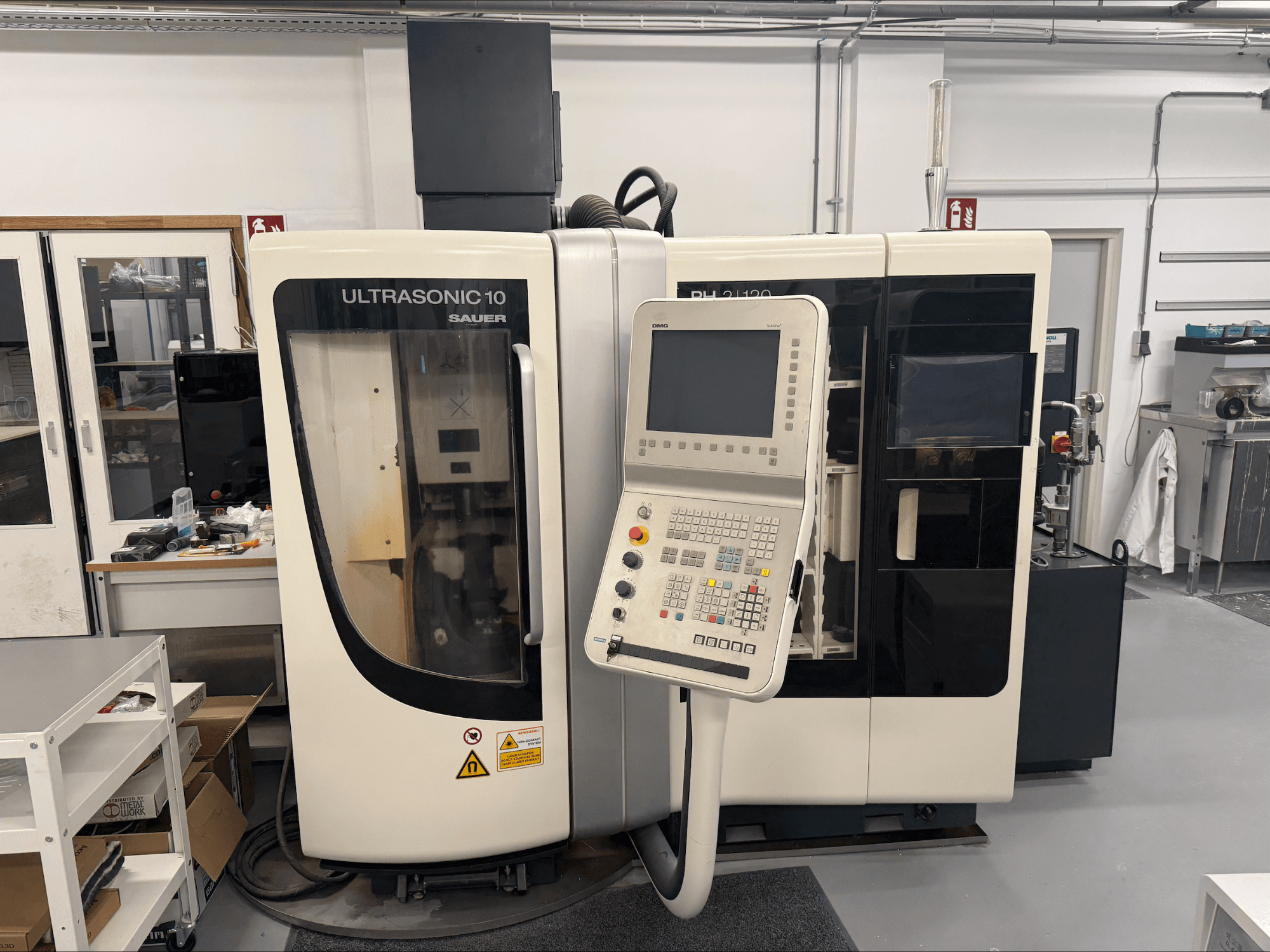 DMG Sauer Ultrasonic 10 + PH 2 | 120 vertikální obráběcí centrum, pohled zepředu, s ovládacím panelem a velkým průhledem.