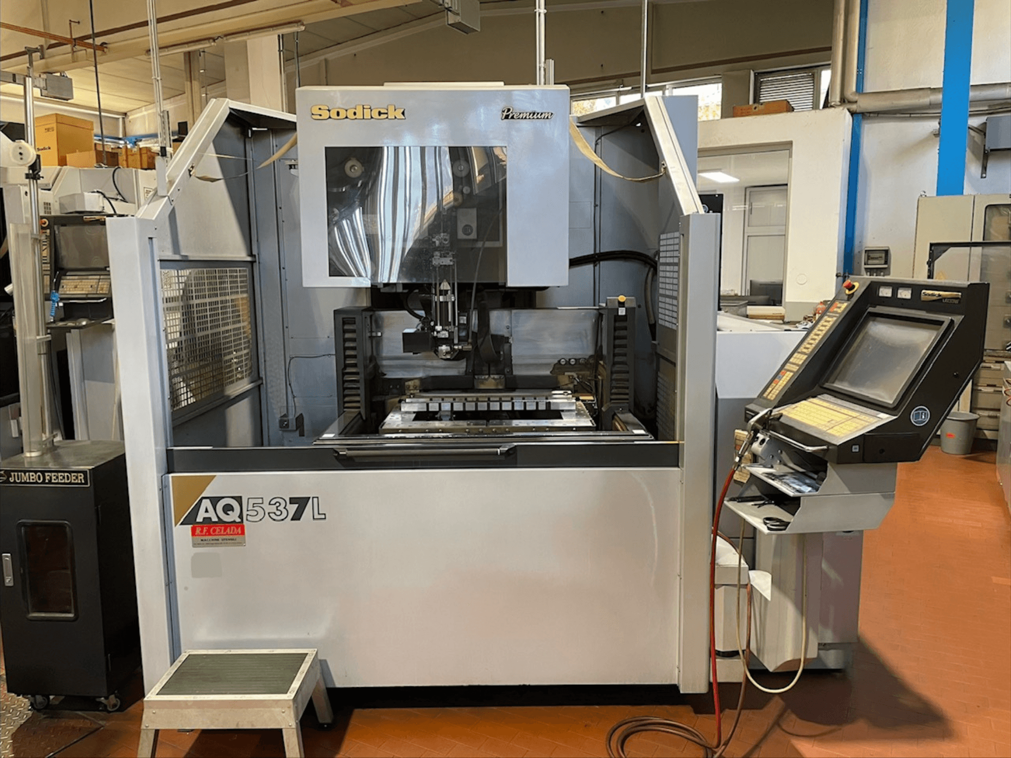 Drátový elektroerozivní stroj Sodick AQ537L v čelním pohledu, ukazuje ovládací panel a obráběcí plochu s viditelnými součástmi.