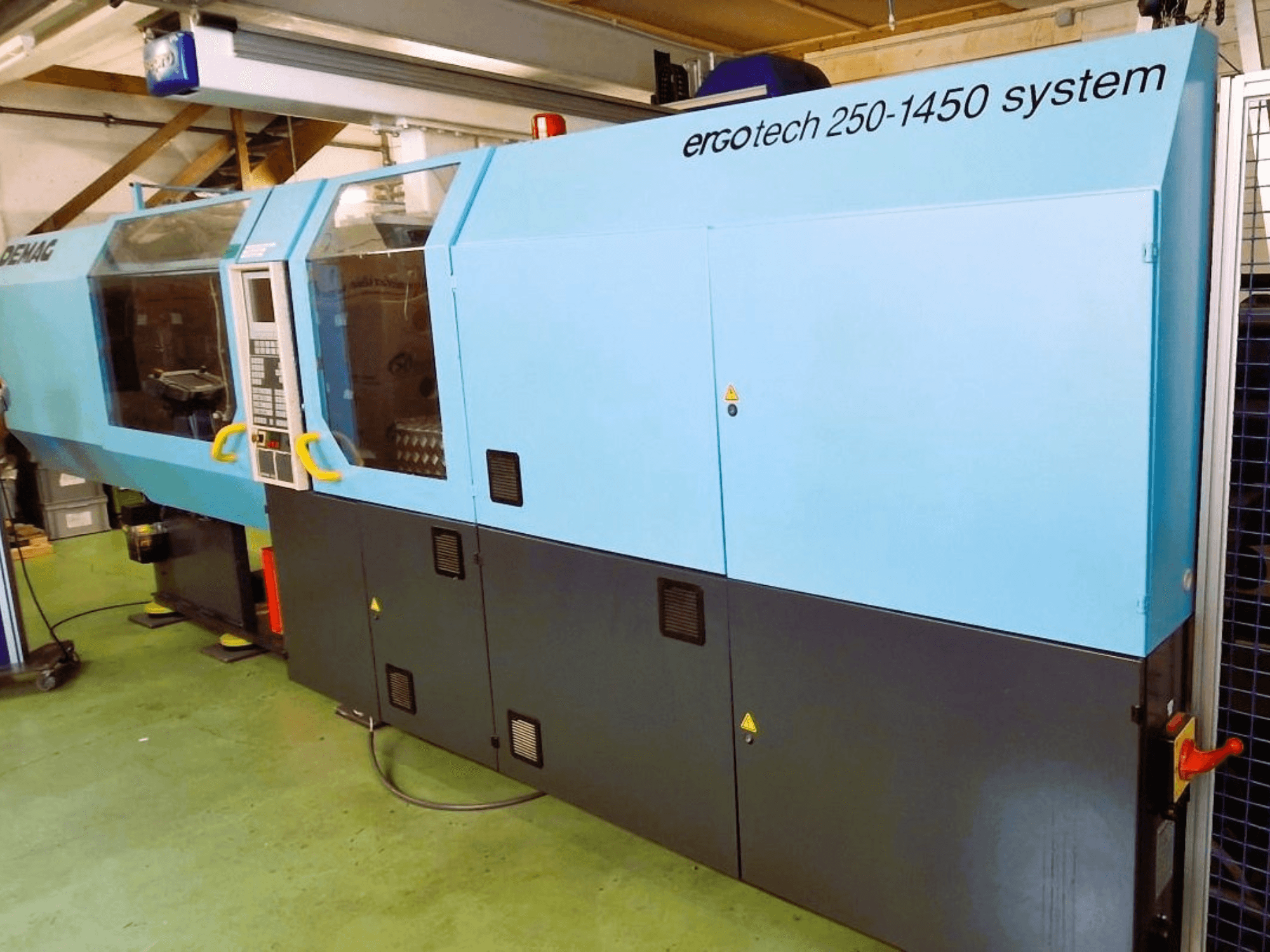 Systémový vstřikovací stroj Ergotech 250-1450, pohled zepředu, modročerná barva, s viditelným ovládacím panelem a bezpečnostními prvky.