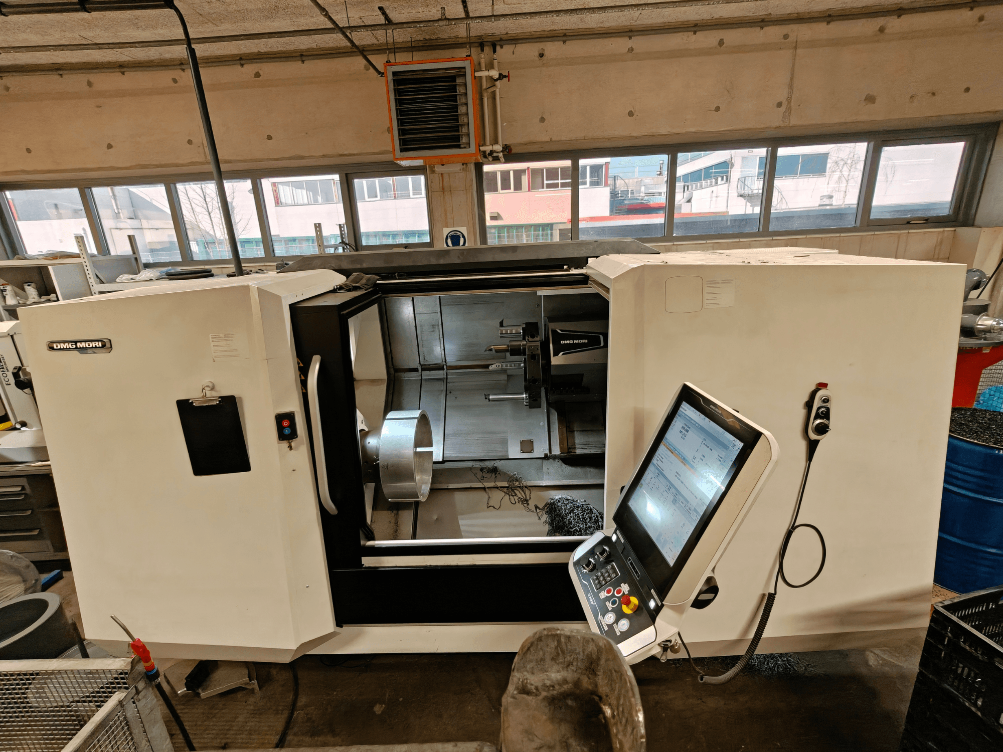 Pohled zepředu na horizontální soustruh DMG MORI CLX 550, který ukazuje ovládací panel a otevřený pracovní prostor.