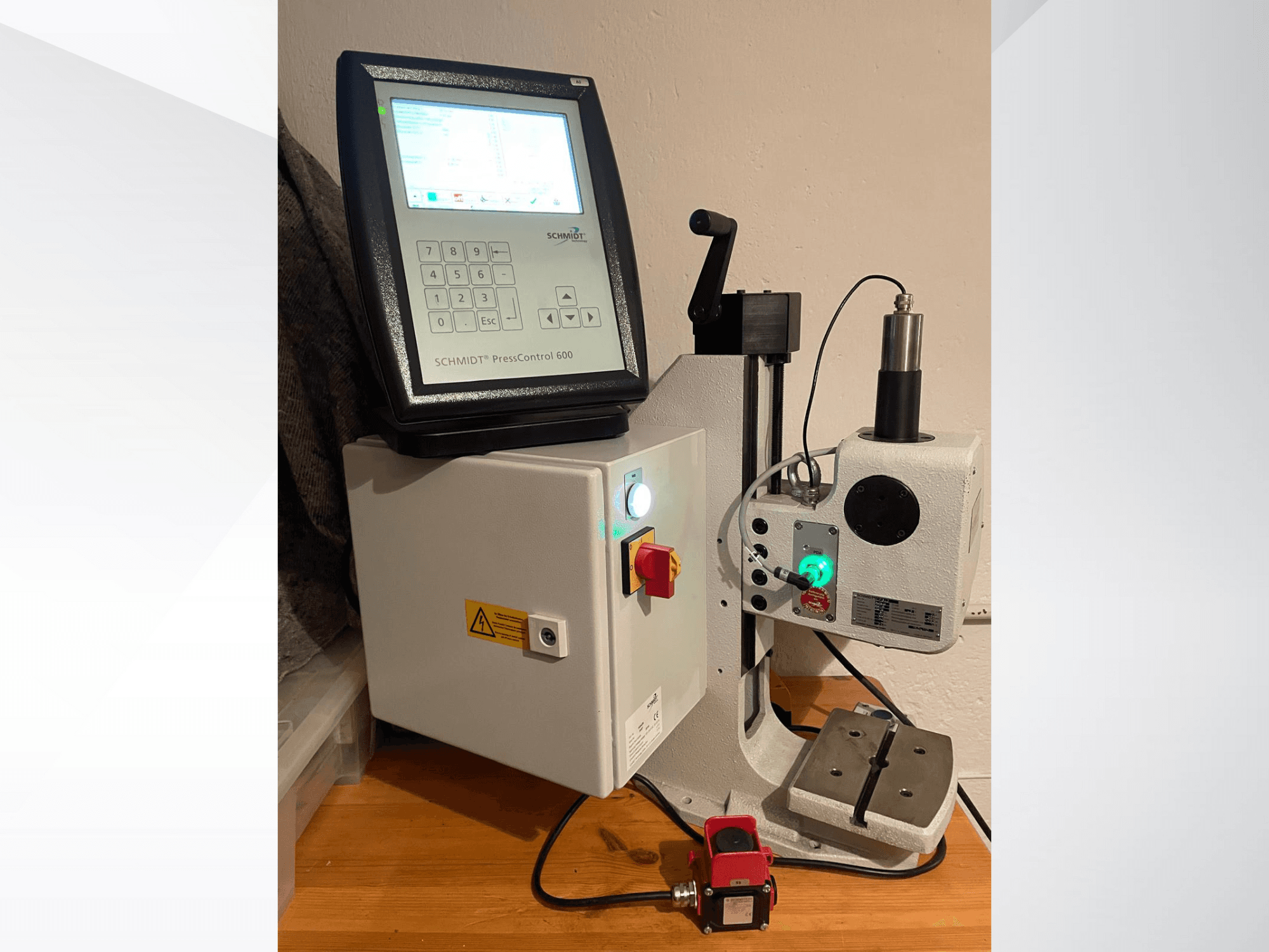 SCHMIDT® PressControl 600, pohled zepředu, ukazuje ovládací panel, tlačítko napájení a hydraulický lis s bezpečnostními prvky.