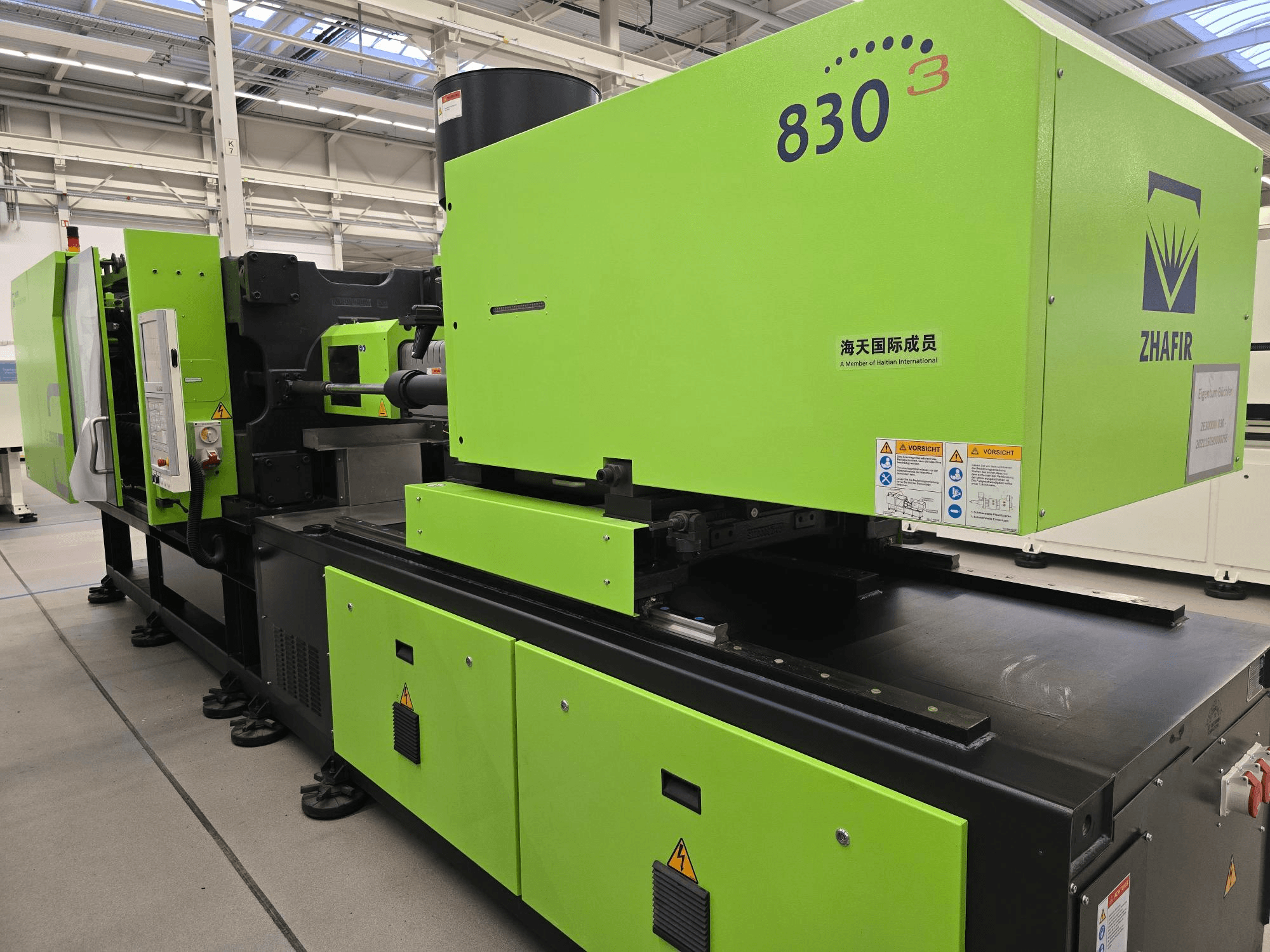 Elektrický vstřikovací stroj ZHAFIR ZERES III 3000/830/B5, boční pohled, s viditelným jasně zeleným krytem a ovládacím panelem.